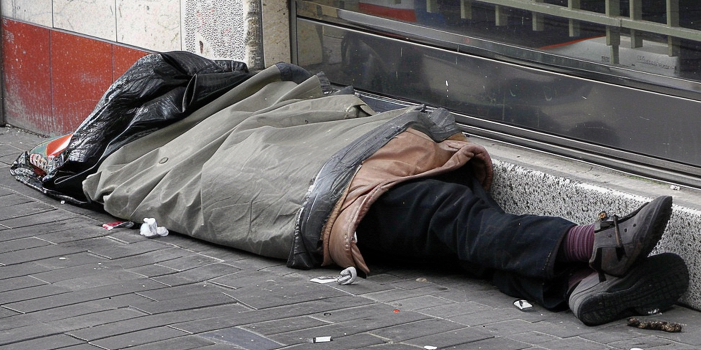 A homeless man sleeping on the sidewalk | Source: Amomama