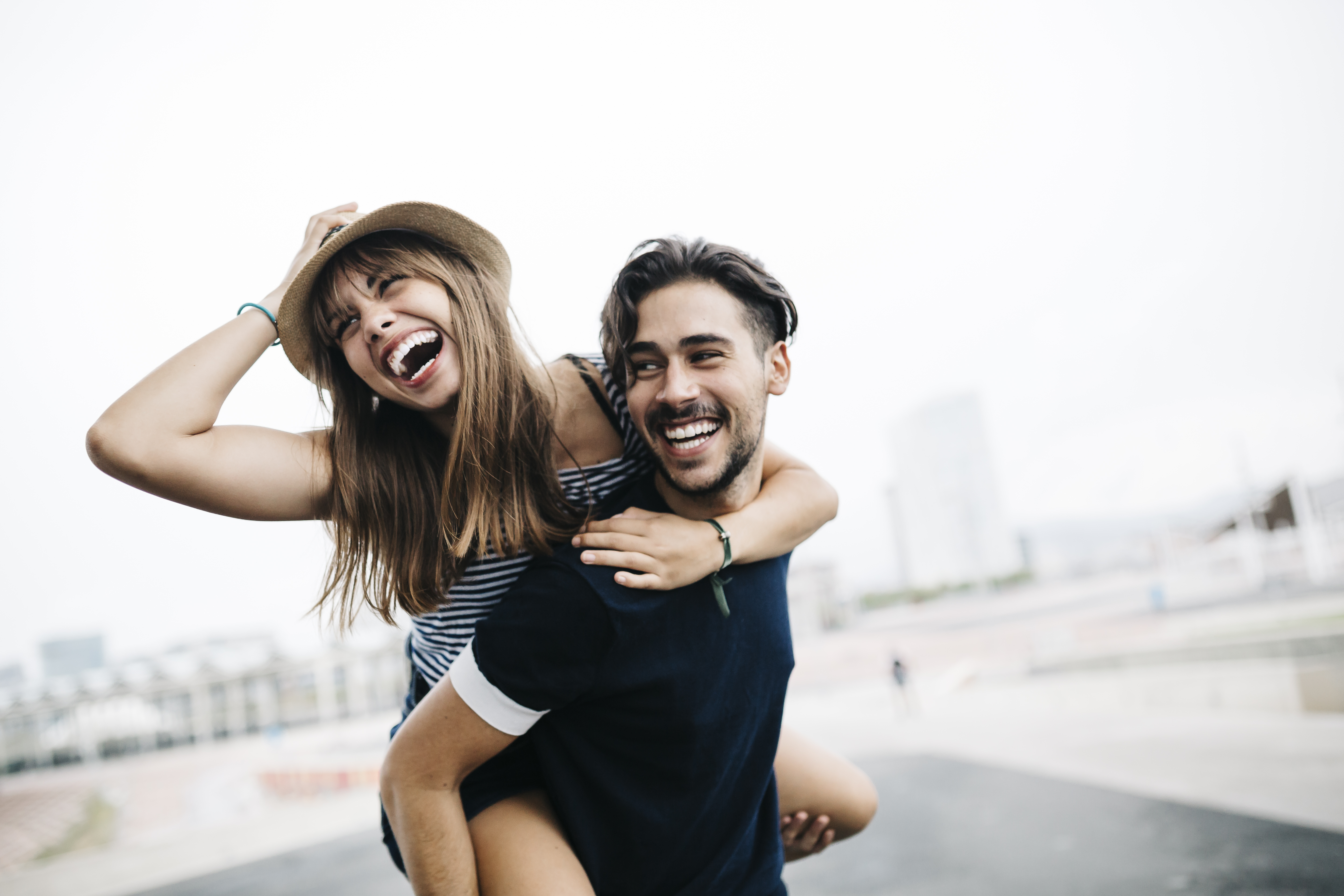 Spain, Barcelona, young man giving his girlfriend a piggyback ride | Source: Getty Images