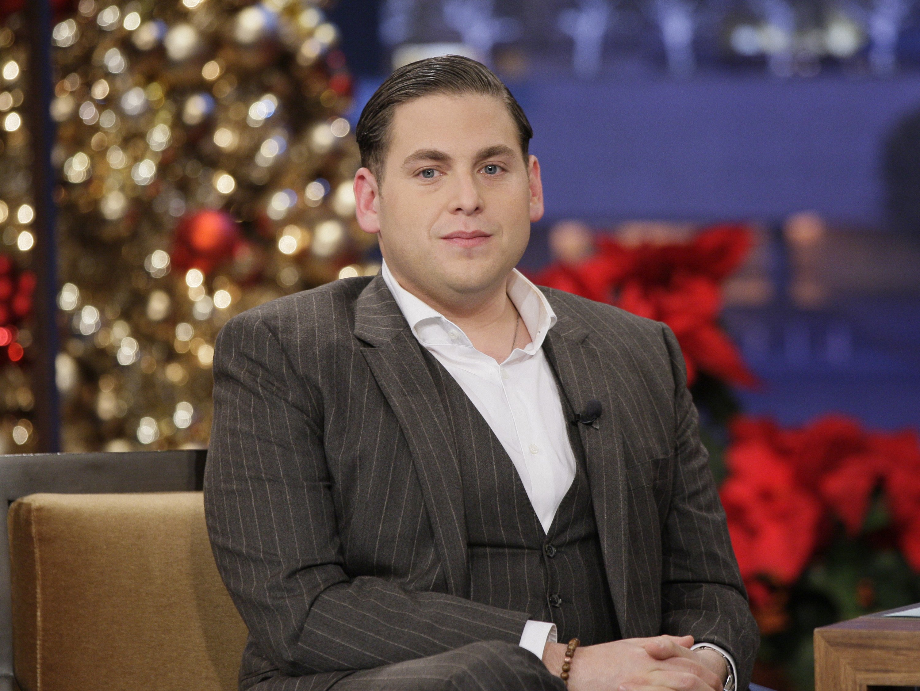 Jonah Hill appeared on "The Tonight Show with Jay Leno" on December 22, 2011, following the significant weight loss he had achieved that year. Wearing a tailored pinstripe three-piece suit with a crisp white shirt and his hair neatly slicked back, the actor displayed a noticeably slimmer face and frame. The appearance offered a striking contrast to the fuller-figured look audiences had become familiar with during his early years in Hollywood.