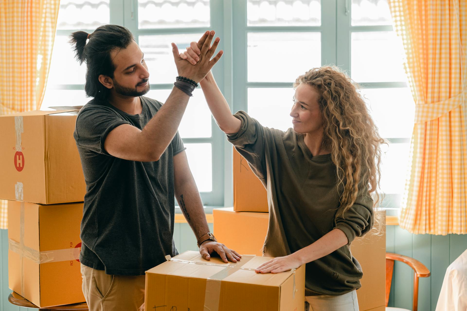 A couple unpacking boxes in their new home | Source: Pexels