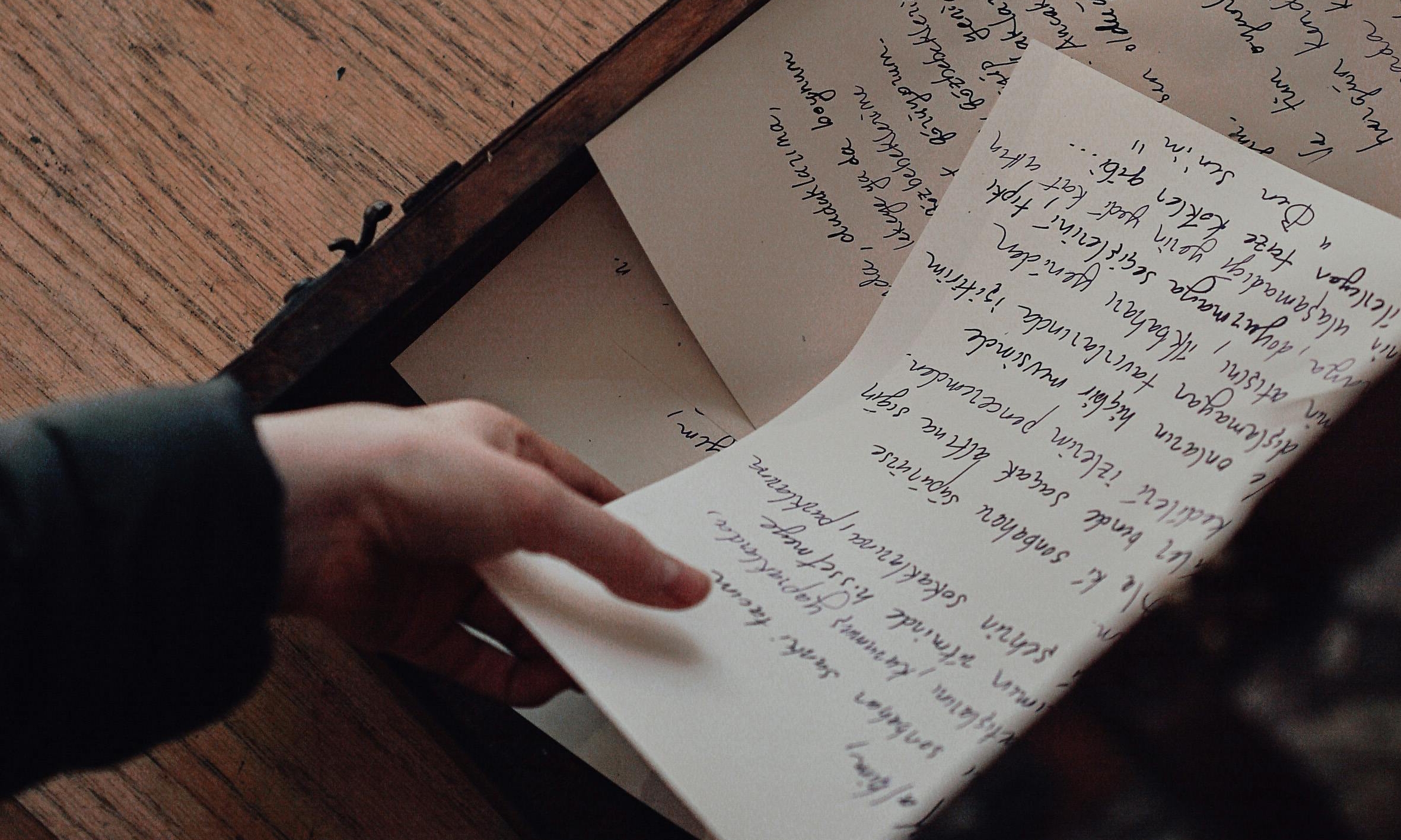 A woman takes up a hand-written letter | Source: Pexels