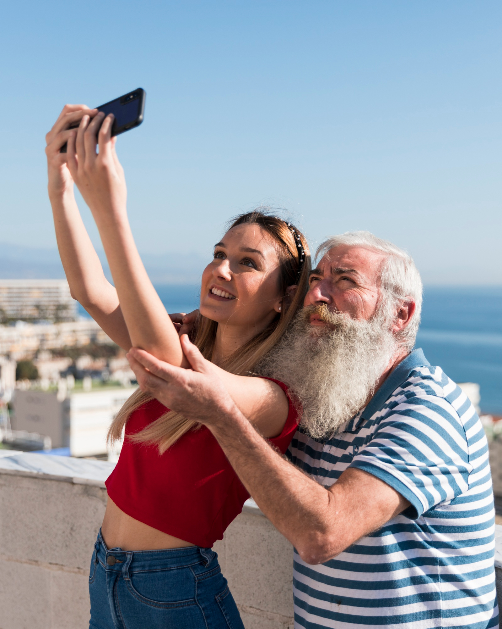 An older man taking a selfie with a young girl | Source: Freepik