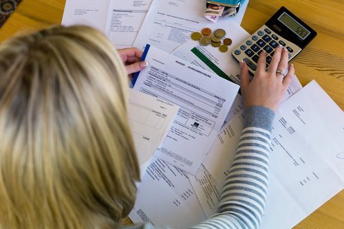 A woman looking through unpaid bills. | Source: Shutterstock.