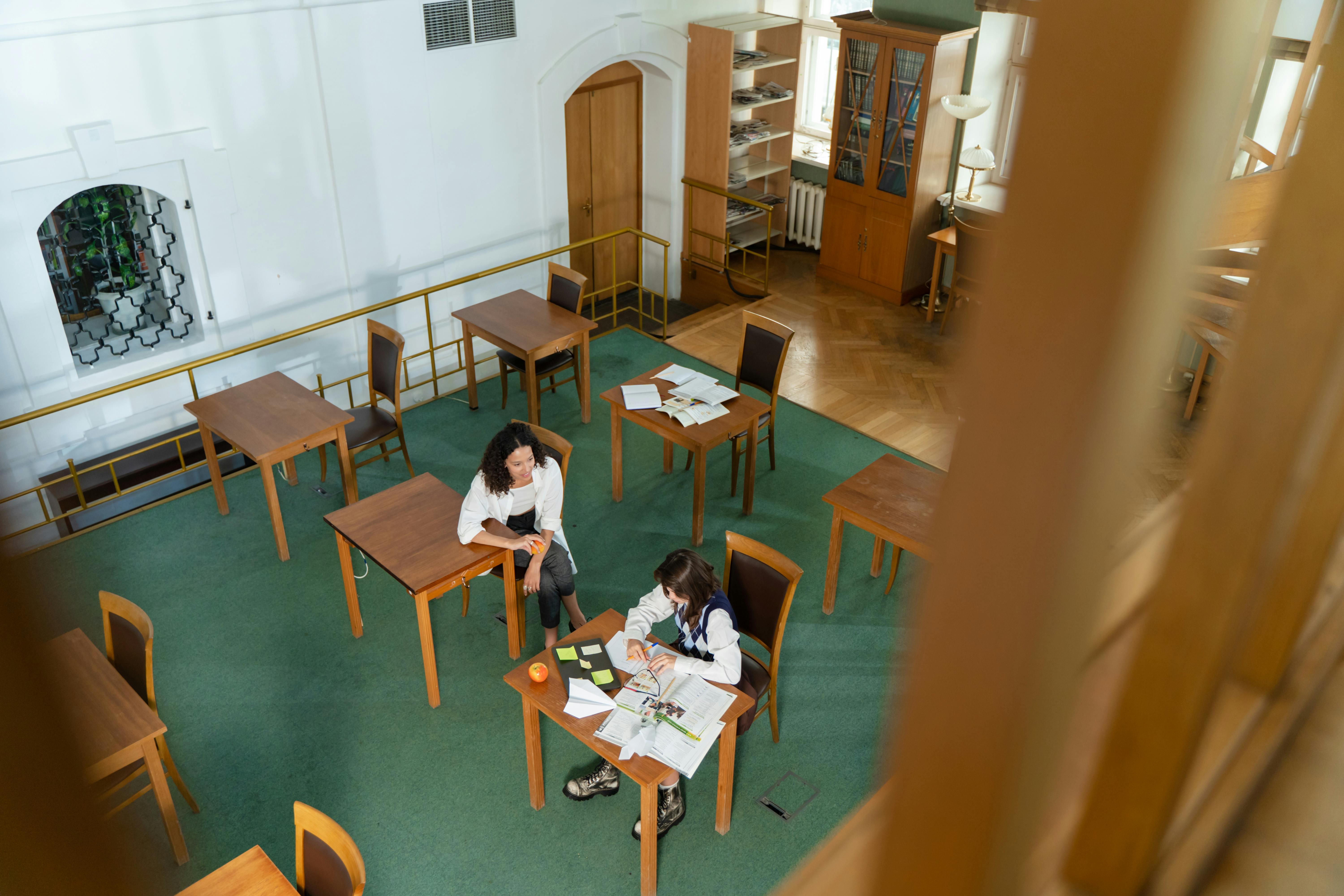 Two young female students in a library | Source: Yaroslav Shuraev on Pexels