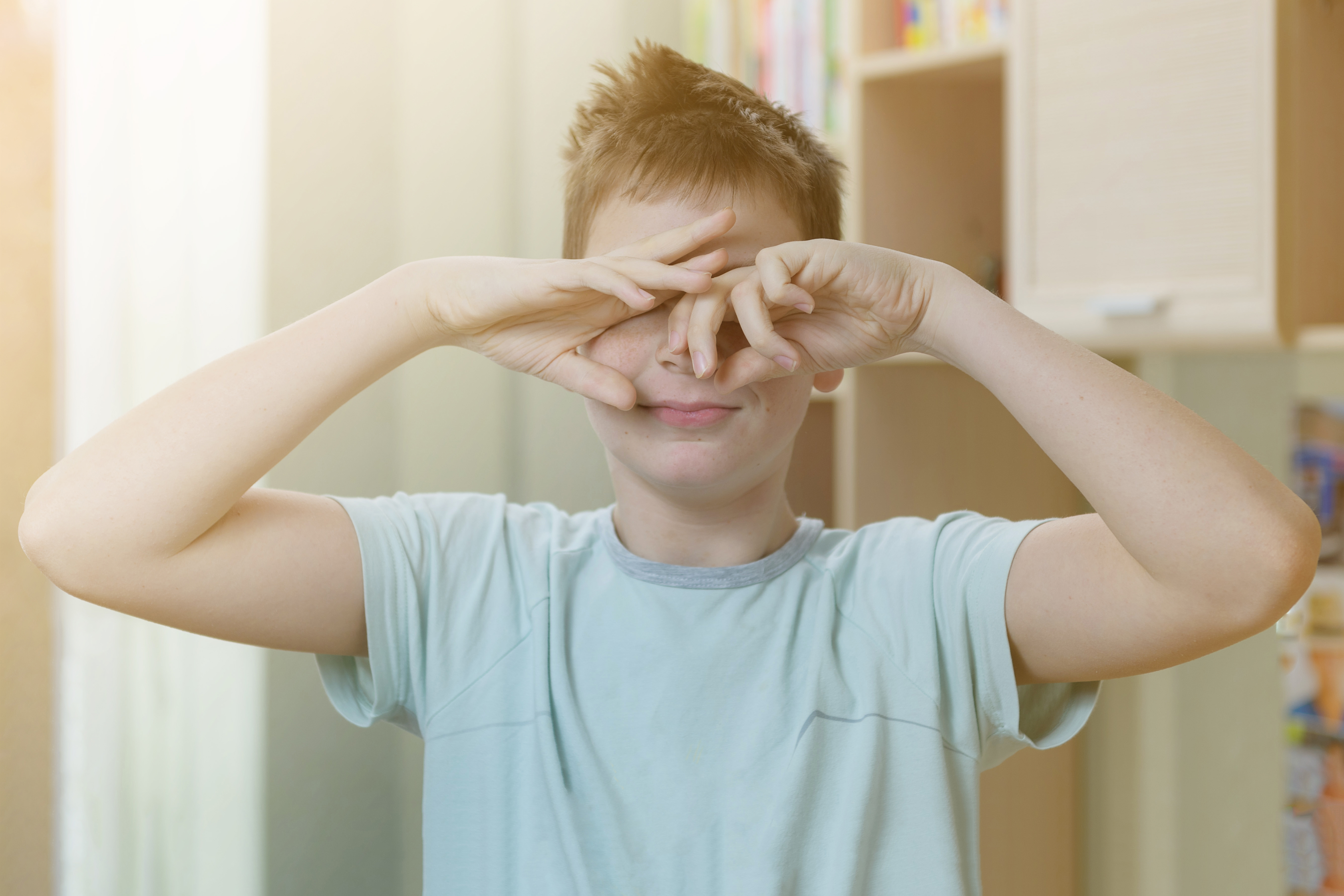 A teenager boy woke up in the morning, is in his room, rubs his eyes. | Source: Shutterstock