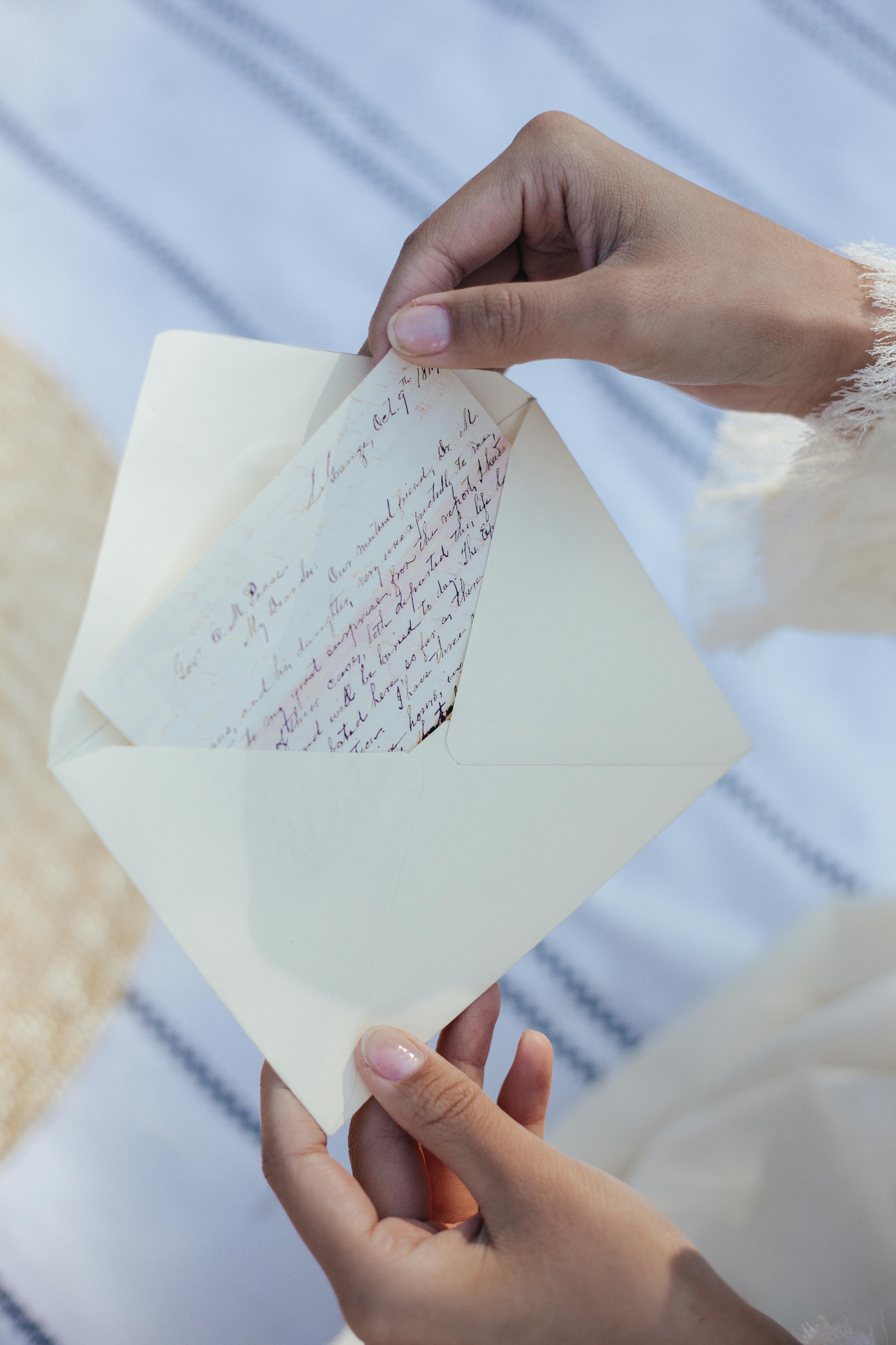 A woman taking out a letter from an envelope | Source: Pexels
