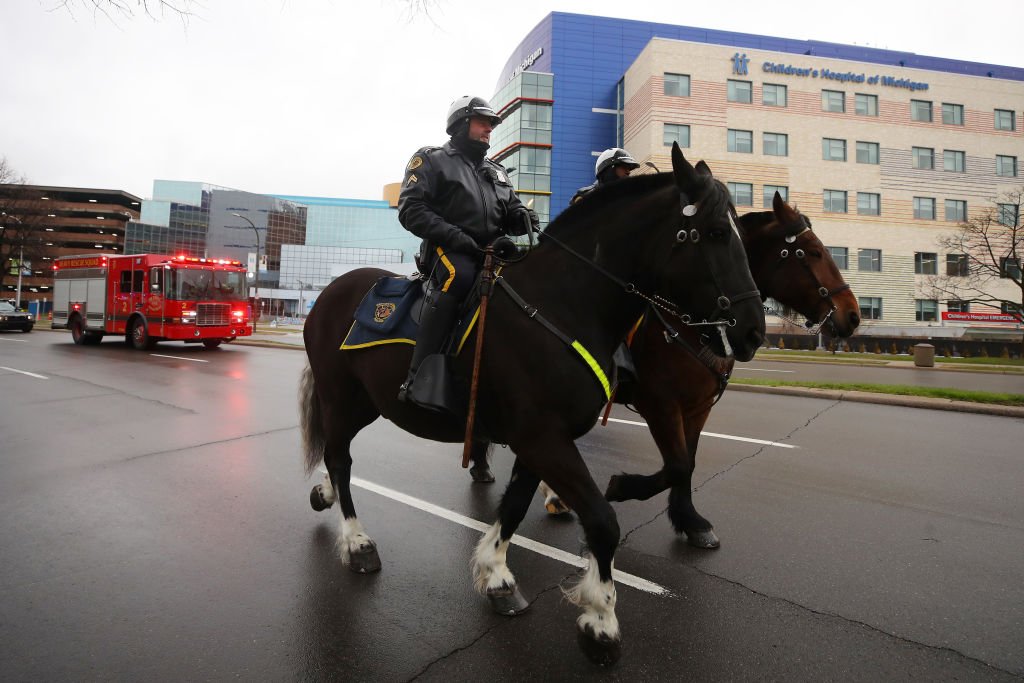 Members of the Detroit Mounted Police pass by the Children's Hospital of Michigan during a parade to support healthcare workers work during the COVID-19 pandemic on April 17, 2020 in Detroit, Michigan | Photo: Getty Images