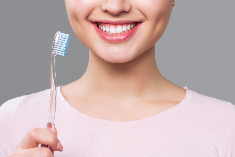 Chica con dientes sanos sosteniendo un cepillo de dientes. | Foto: Shutterstock