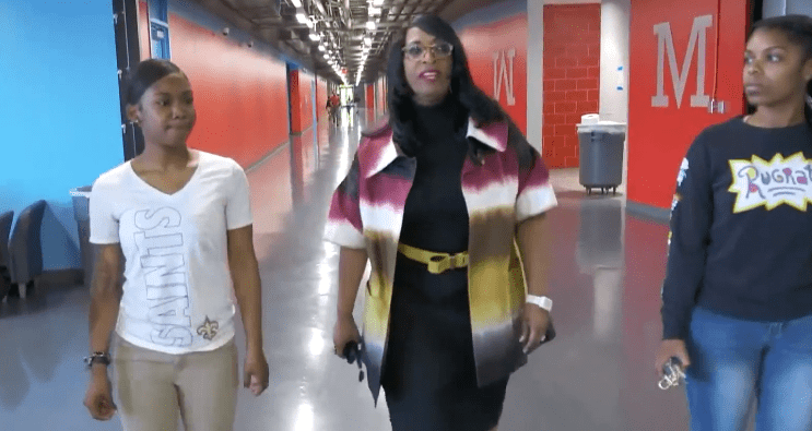 Principal Carlotta Brown walking down the hallway with two students