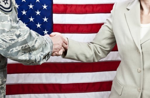 Handshake between enlisted military member and a female civilian | Photo: Getty Images
