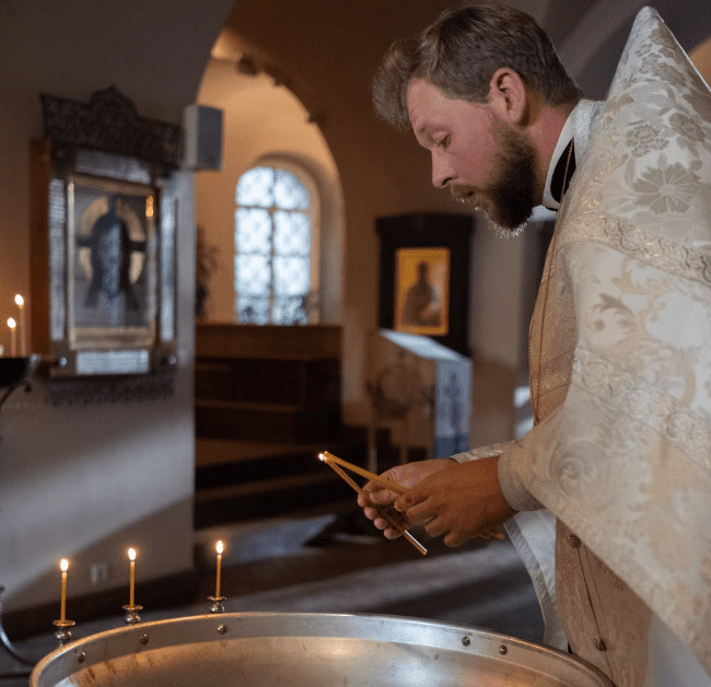 Church official lighting candles. | Source: Pexels
