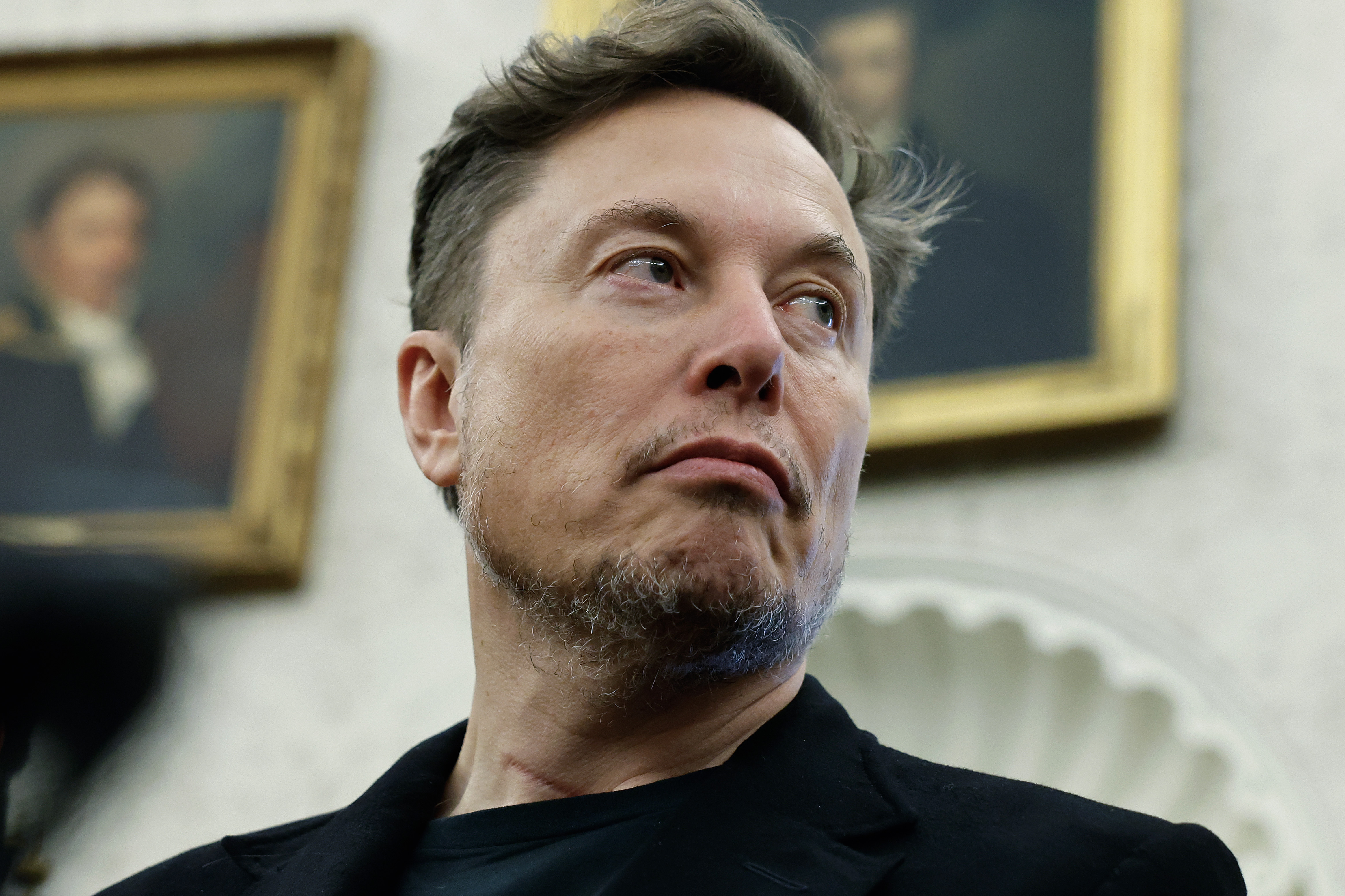 Elon Musk listens as reporters ask President Donald Trump and South Africa President Cyril Ramaphosa questions during a press availability at the White House on May 21, 2025, in Washington, D.C. | Source: Getty Images
