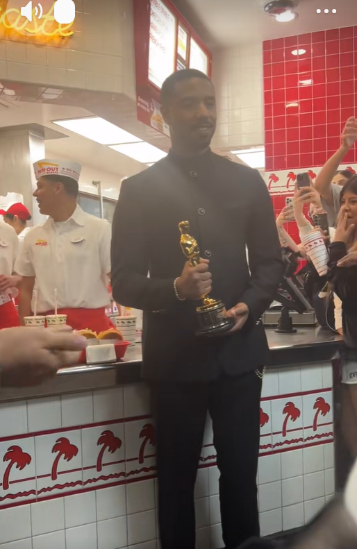 Michael B. Jordan stands inside In-N-Out Burger holding his Oscar as employees work behind the counter and fans nearby lift their phones to take photos. | Source: TikTok/donovanfilmz