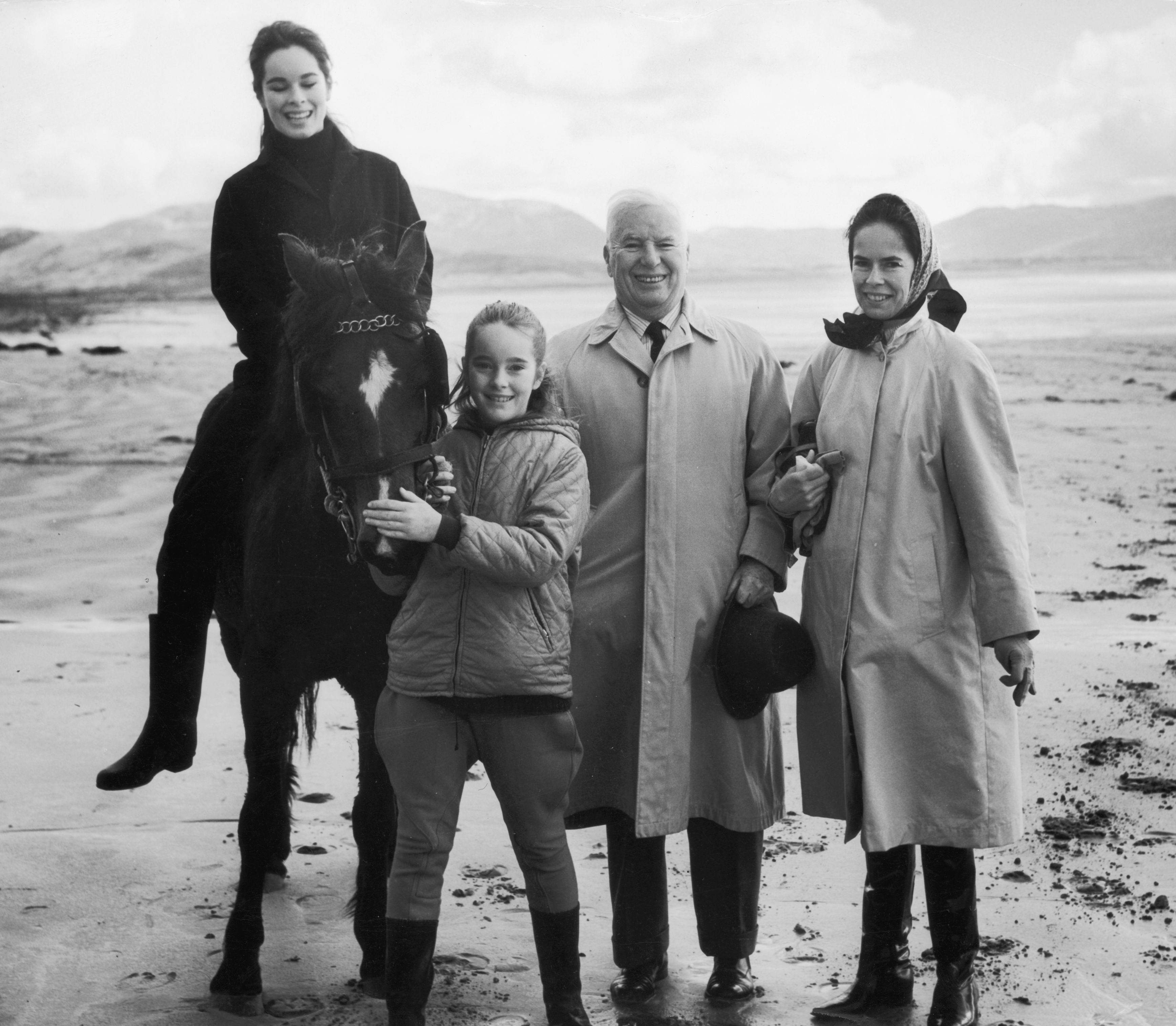 Charlie Chaplin stands with his wife Oona and two of his daughters, Geraldine and Jane, near a lake in Ireland circa 1965 | Source: Getty Images