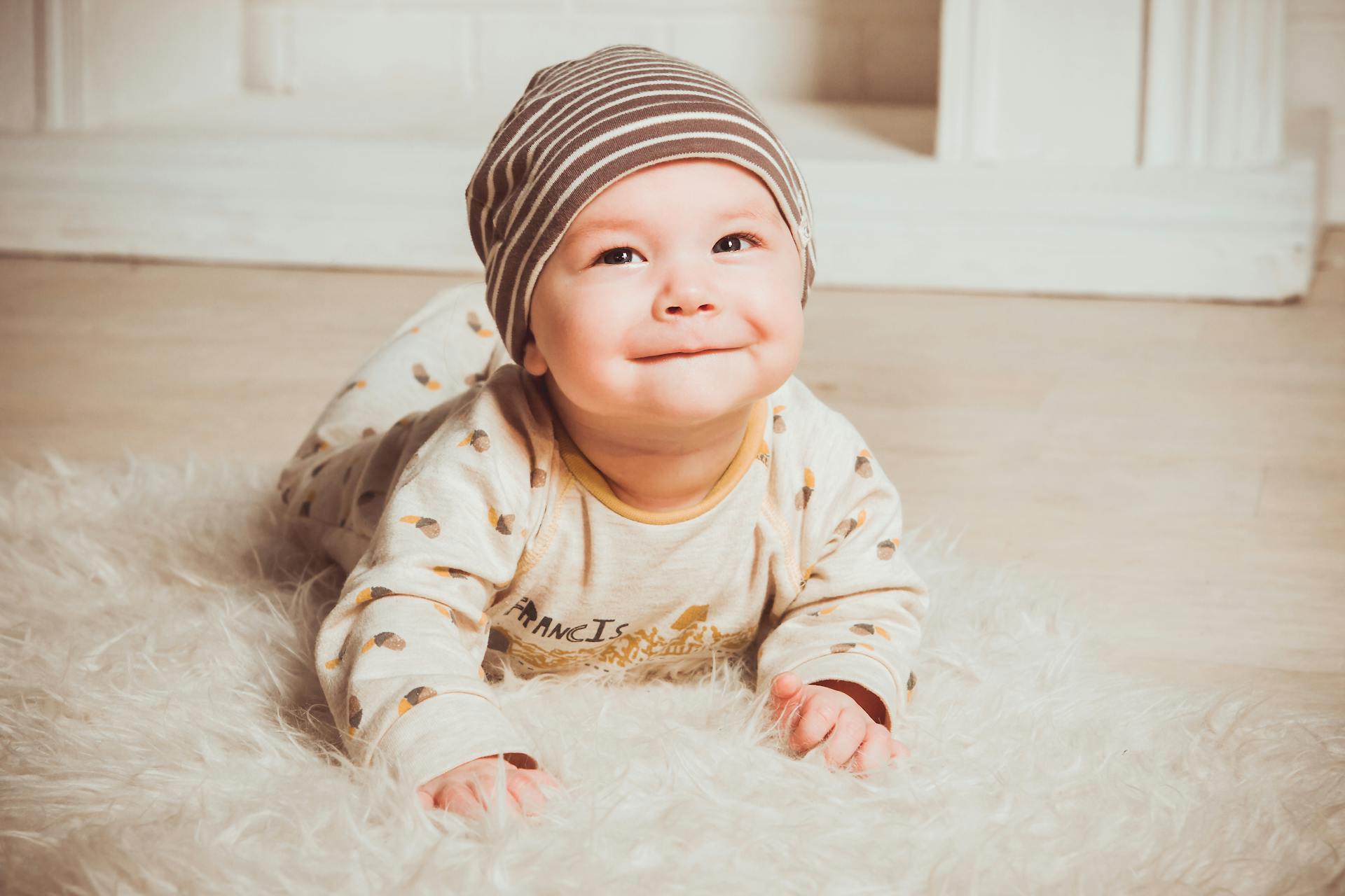 A baby crawling on a fur rug | Source: Pexels