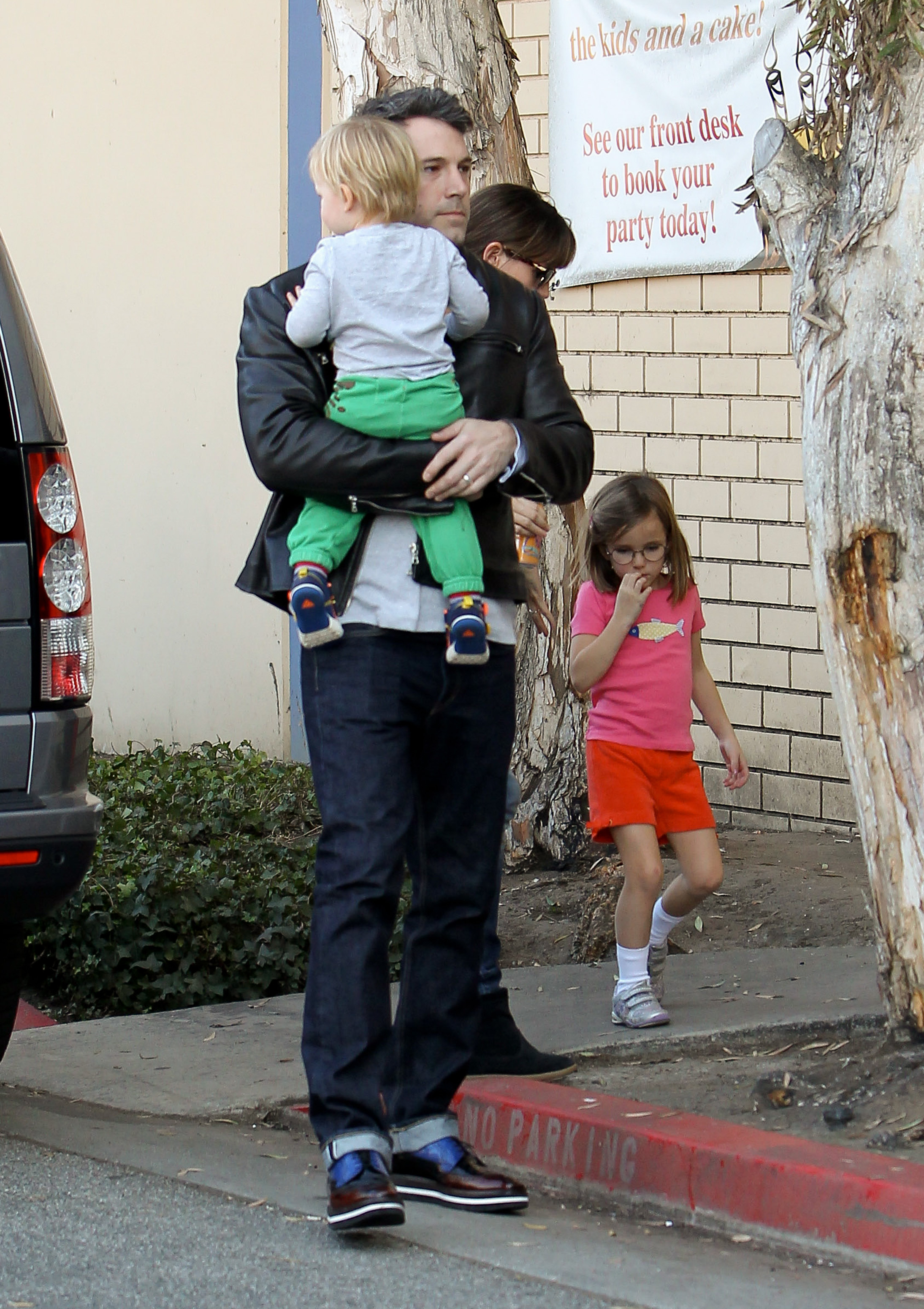 Ben Affleck walks with Samuel Garner Affleck close to his chest while Jennifer Garner walks behind with their daughter Seraphina Affleck on November 9, 2013, in Los Angeles, California. | Source: Getty Images