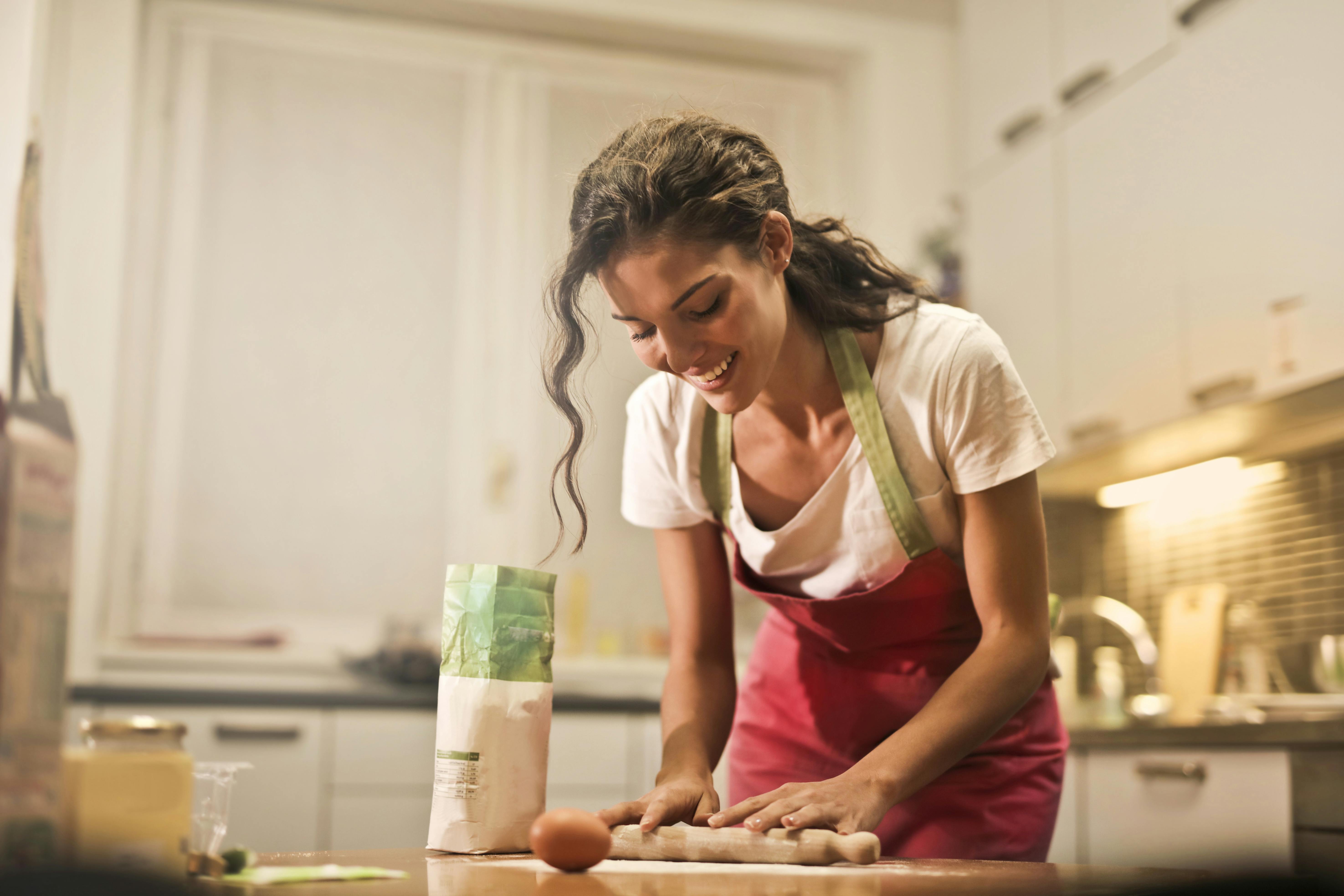 Happy woman with rolling pin cooking at home | Source: Pexels