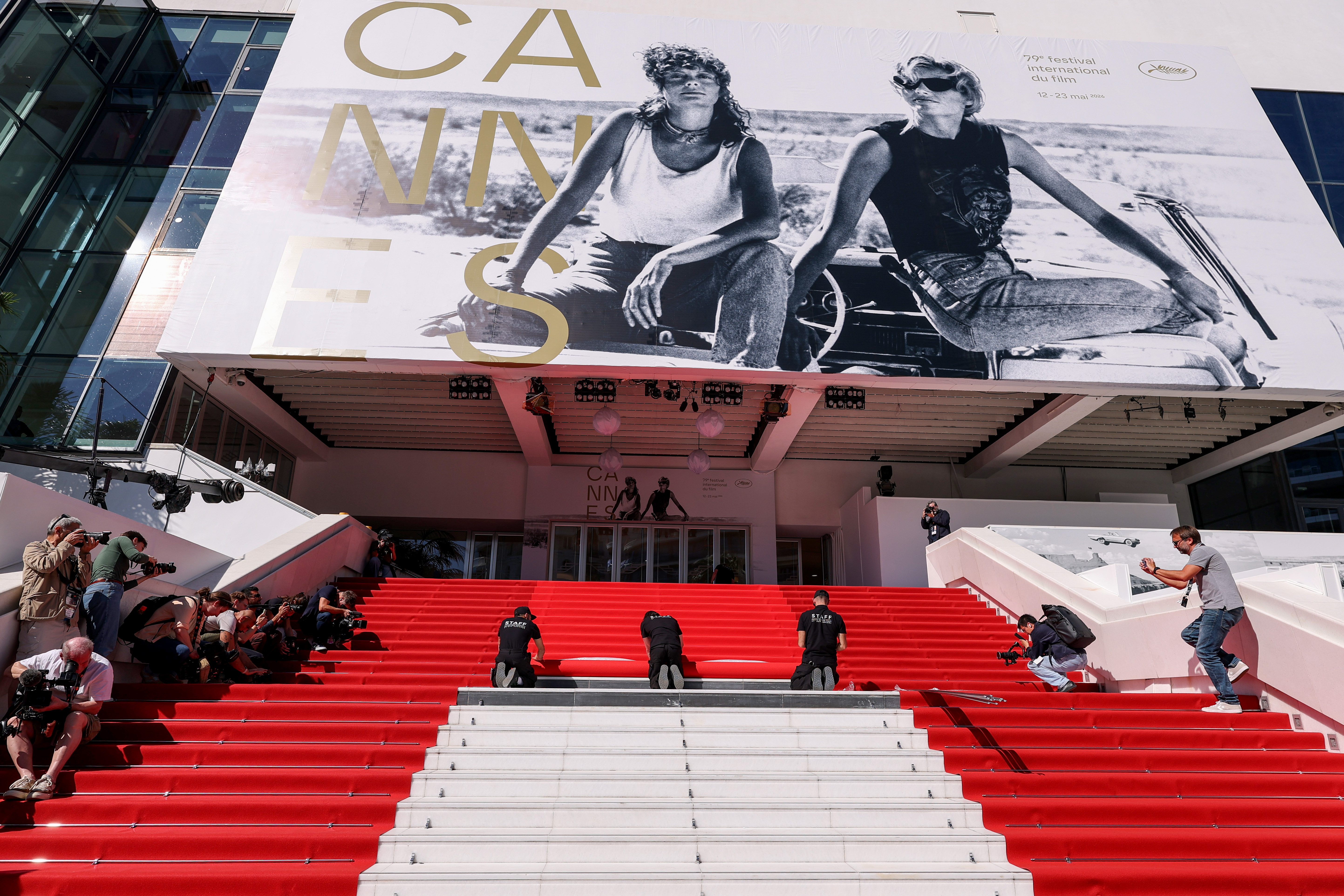 Staff members work on the red carpet roll out ahead of the 79th annual Cannes Film Festival on May 12, 2026 in France | Source: Getty Images