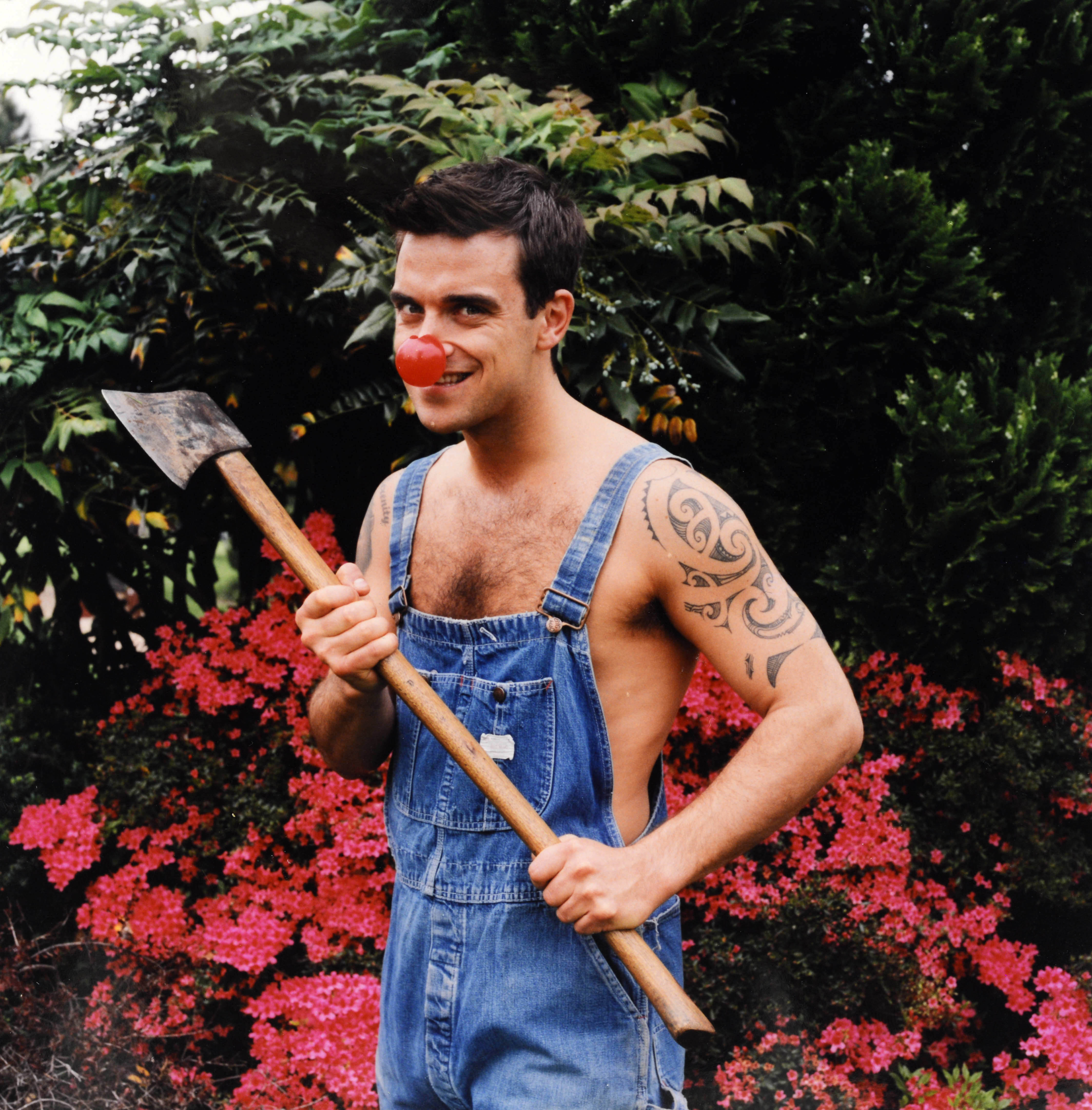 Robbie Williams appeared in character during a special Red Nose Day episode of "The Fast Show" in 2001. Dressed in denim overalls, clown nose, and holding a spade, the cameo highlighted his playful spirit and support for Comic Relief's fundraising efforts.