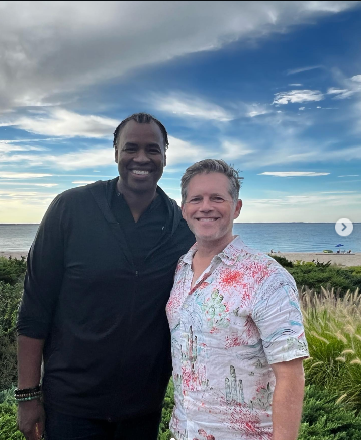 Jason Collins smiles beside his husband, Brunson Green, as the couple pose together near the waterfront under a bright blue sky during a scenic outdoor outing. | Source: Instagram/jasoncollins_98