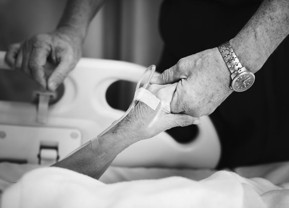Un mari réconfortant sa femme malade à l'hôpital. | Photo: Pexels