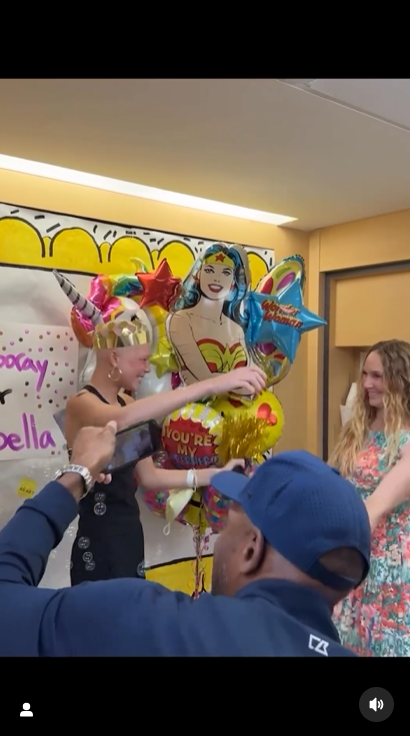 Isabella Strahan hugs her mother, Jean Muggli, while her father, Michael Strahan, films her ringing the bell at the hospital, June 2024. | Source: Instagram/michaelstrahan