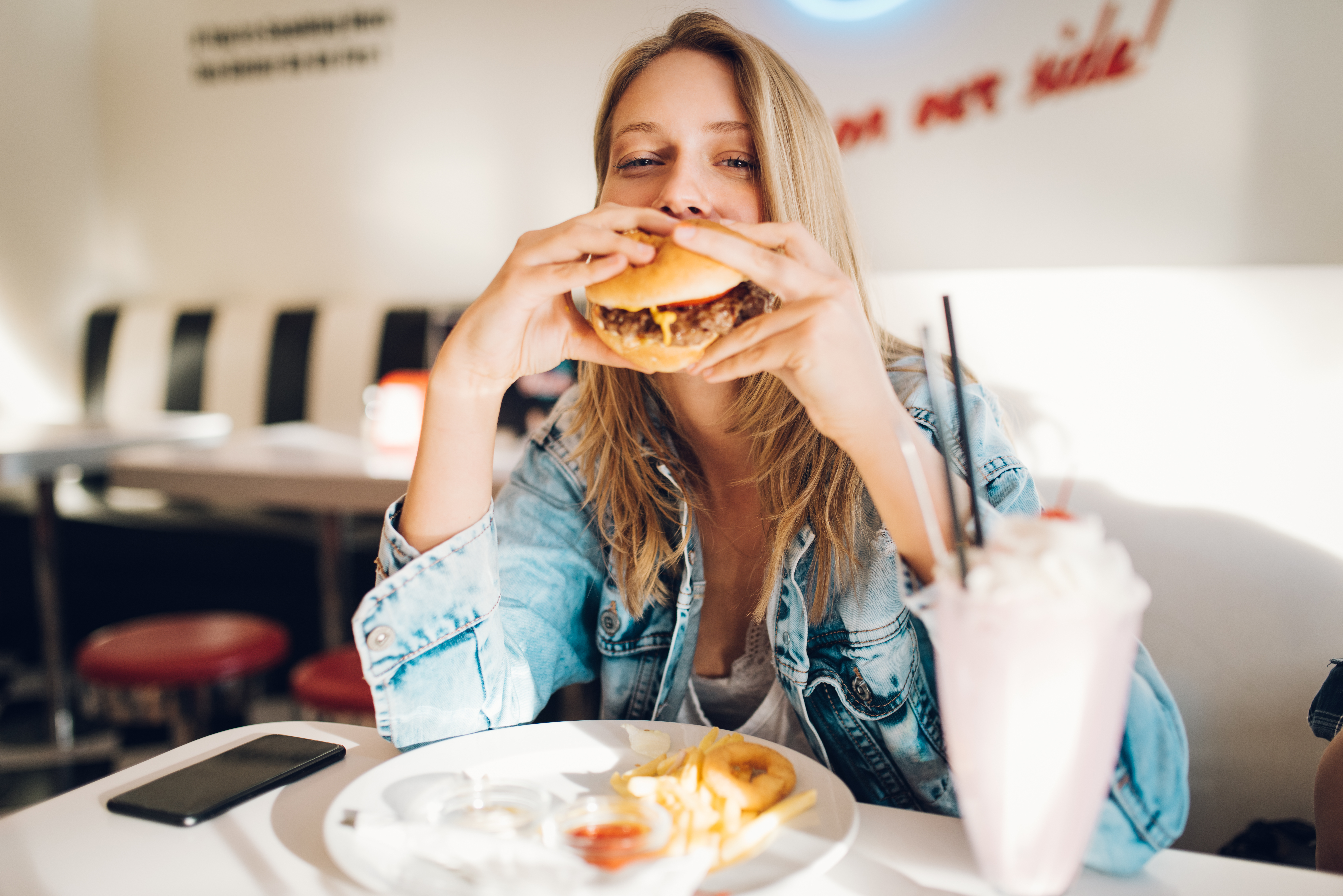 A woman eating a burger | Source: Shutterstock