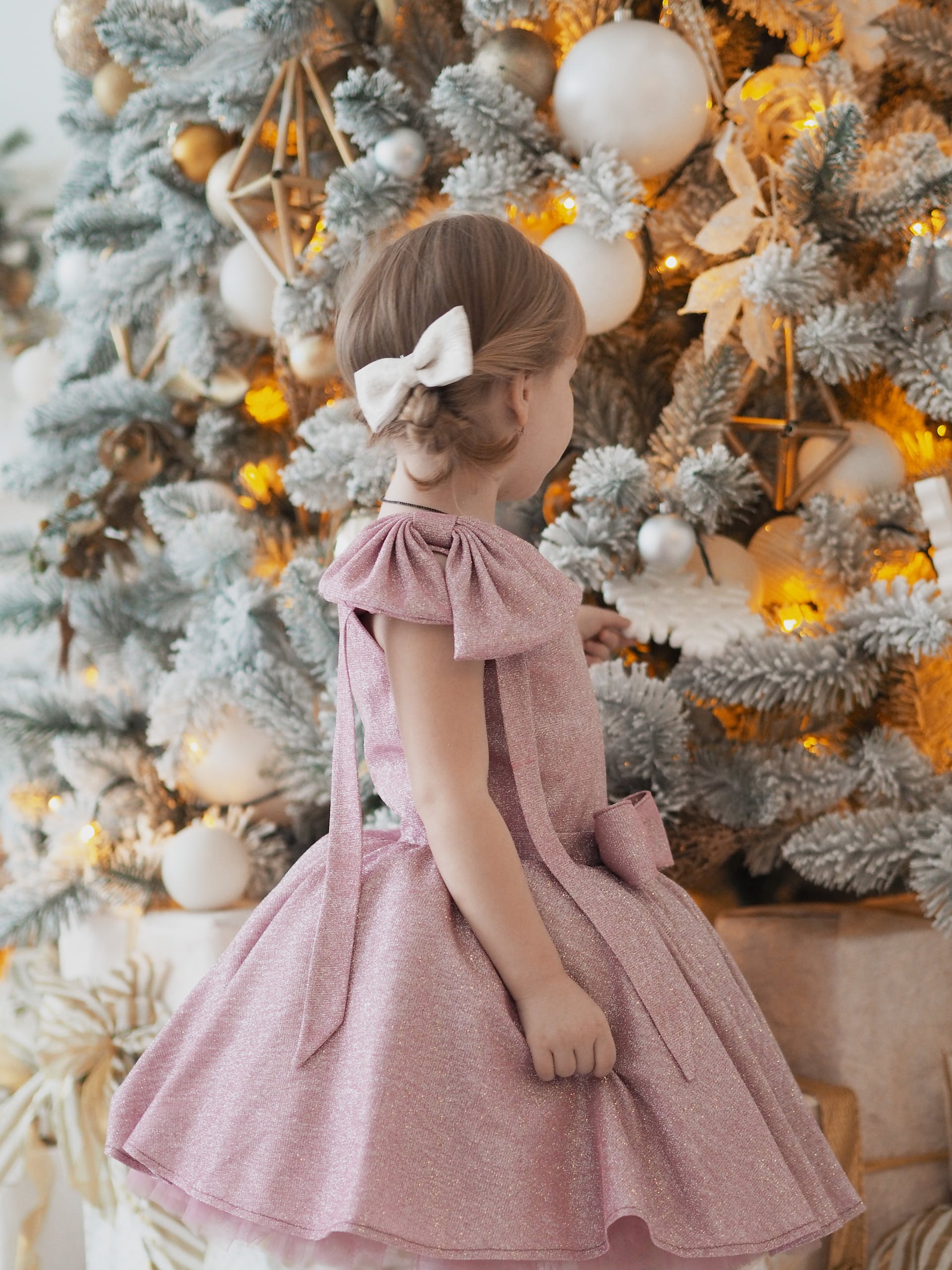 A little girl looking at a Christmas tree | Source: Pexels