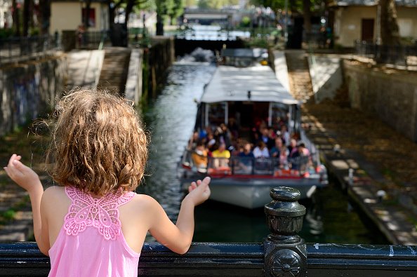 Petite fille regardant un bateau de croisière "Canauxrama".| Photo : Getty Images