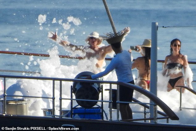 Bezos partied in the foam as Sanchez took pictures