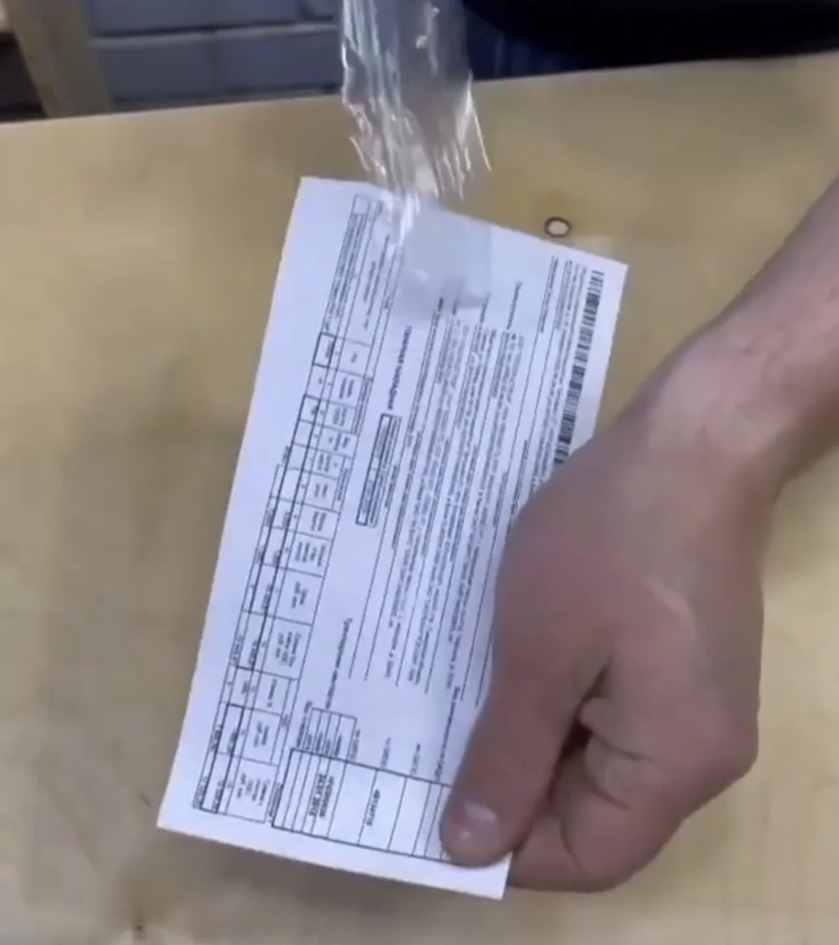 A closeup of a person easily removing transparent tape from a document, as seen in a video shared online | Source: Reddit/r3dl3mon