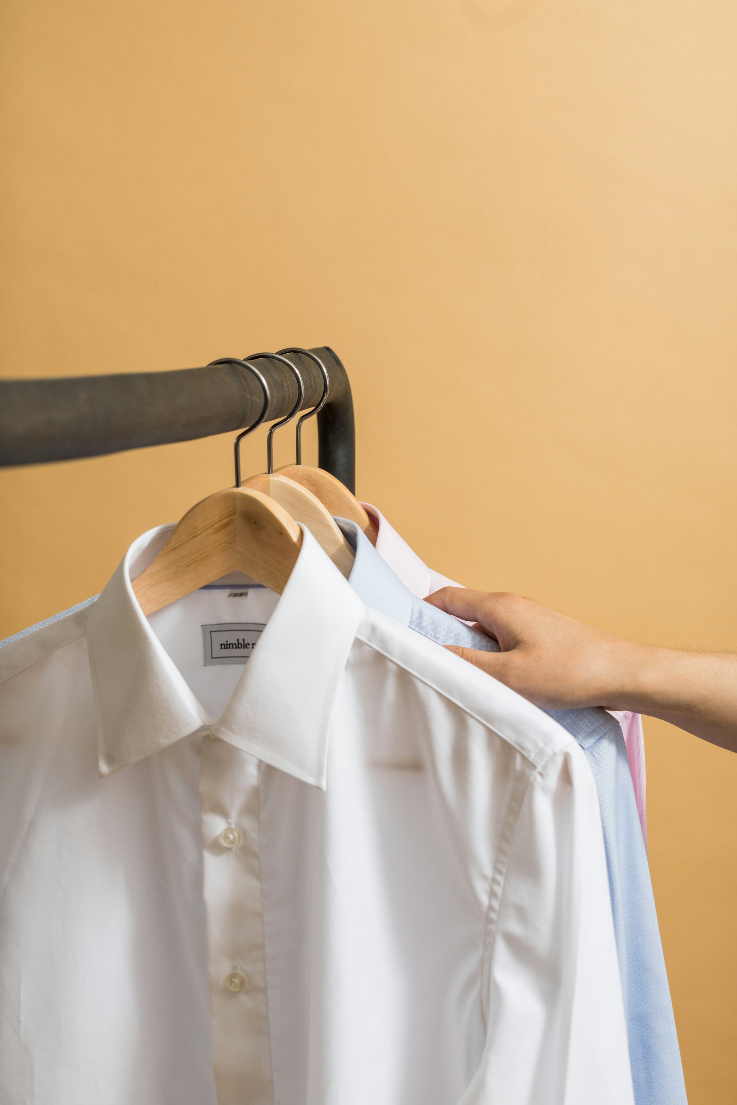 Formal shirts on hangers | Source: Unsplash