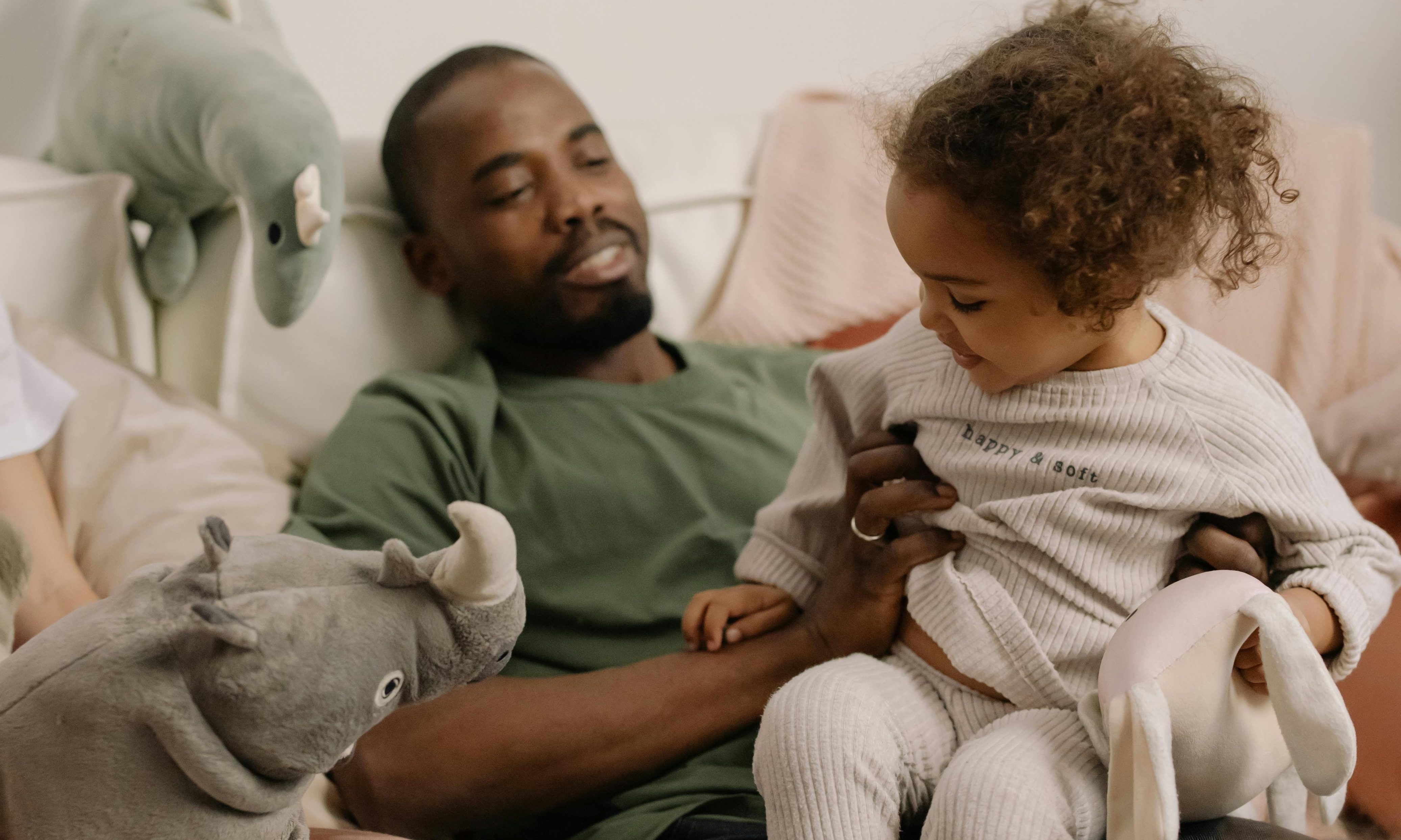 A man with a child on his lap | Source: Pexels