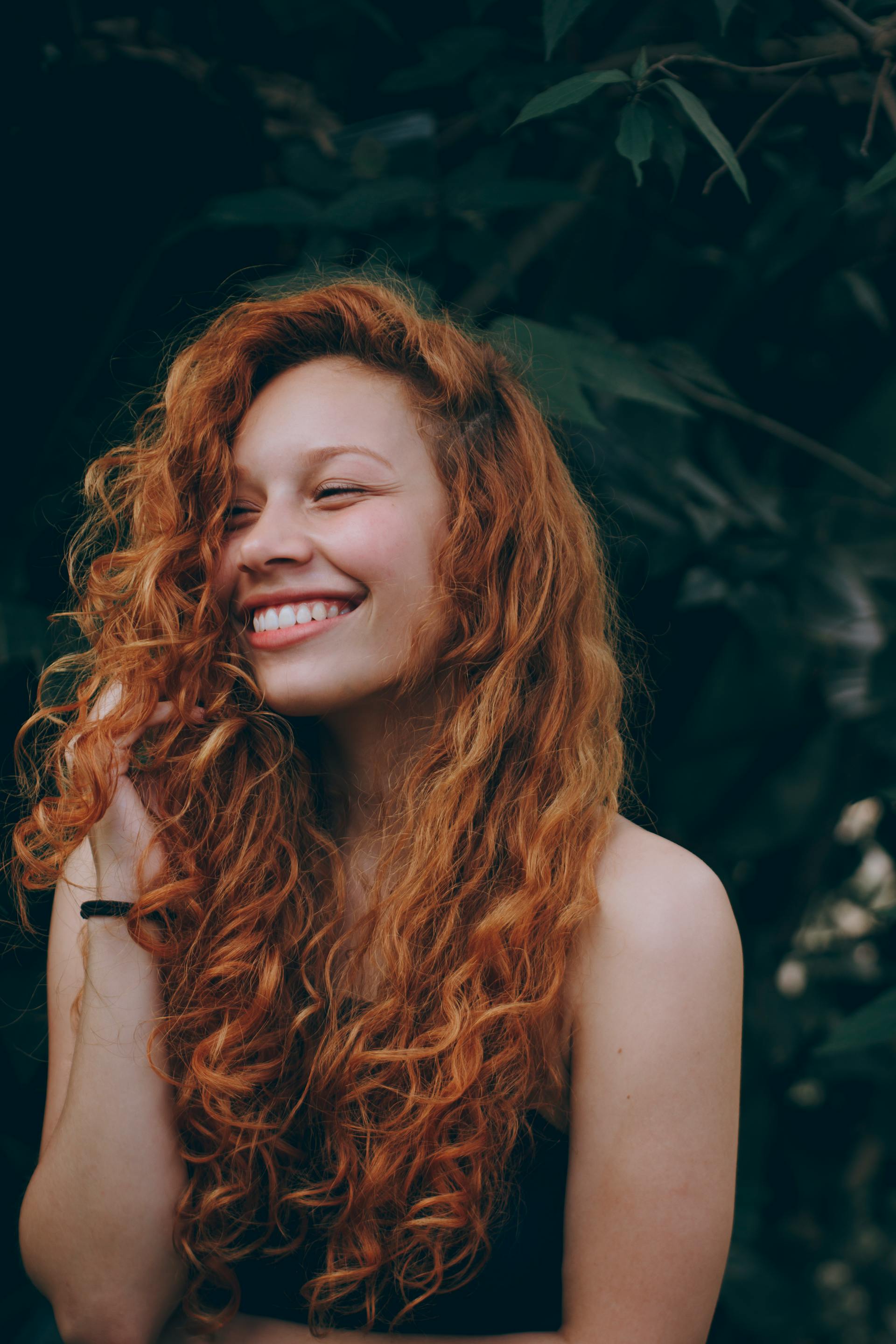 A smiling woman with red hair | Source: Pexels