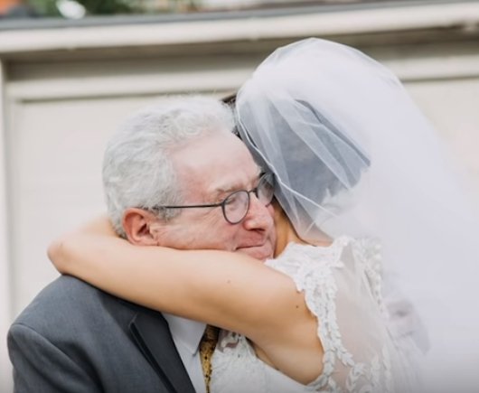 Jim Stamp receiving a hug from the bride, daughter Gina. | Source: YouTube/GMA