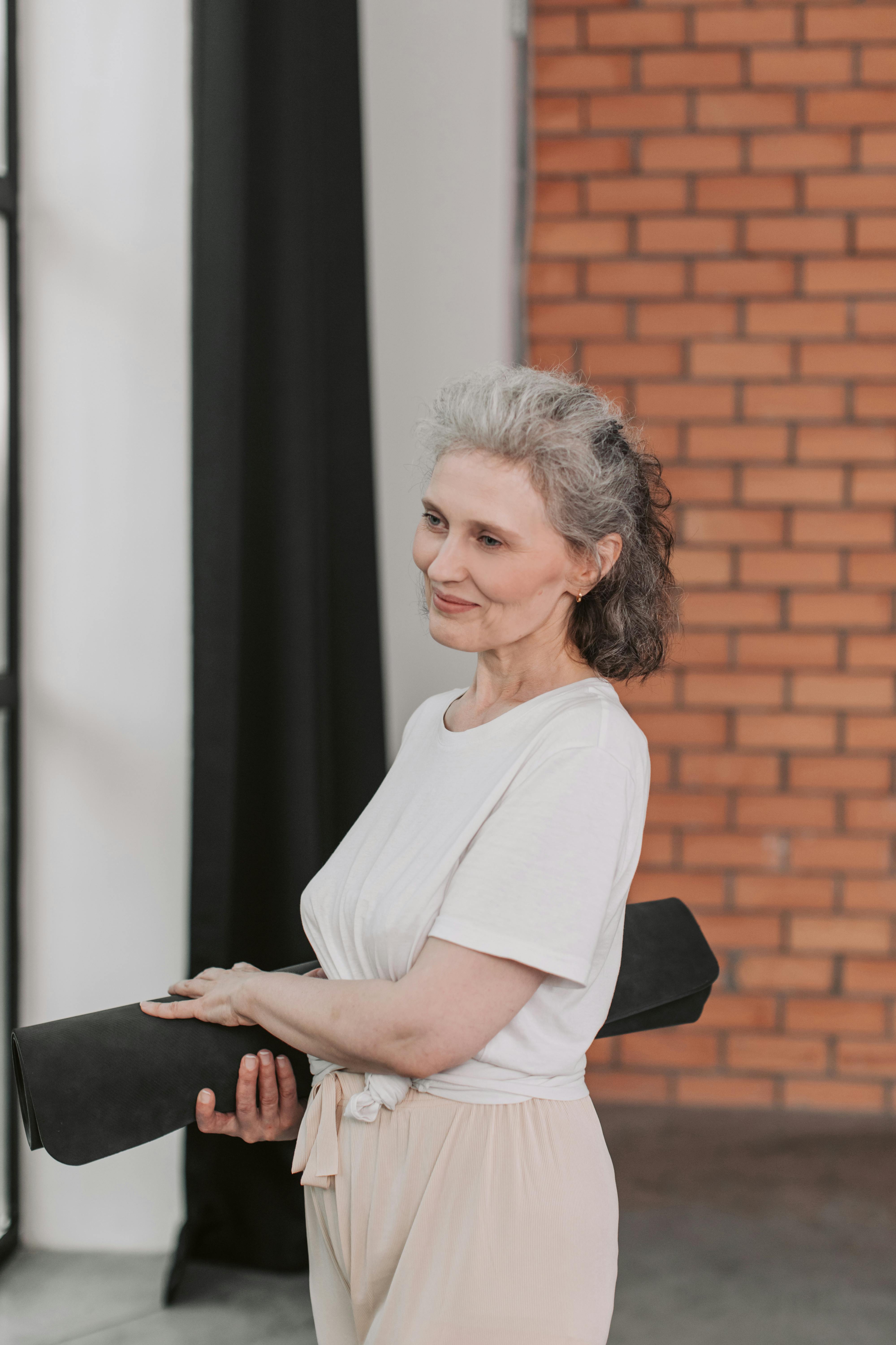An older woman holding a yoga mat | Source: Getty Images
