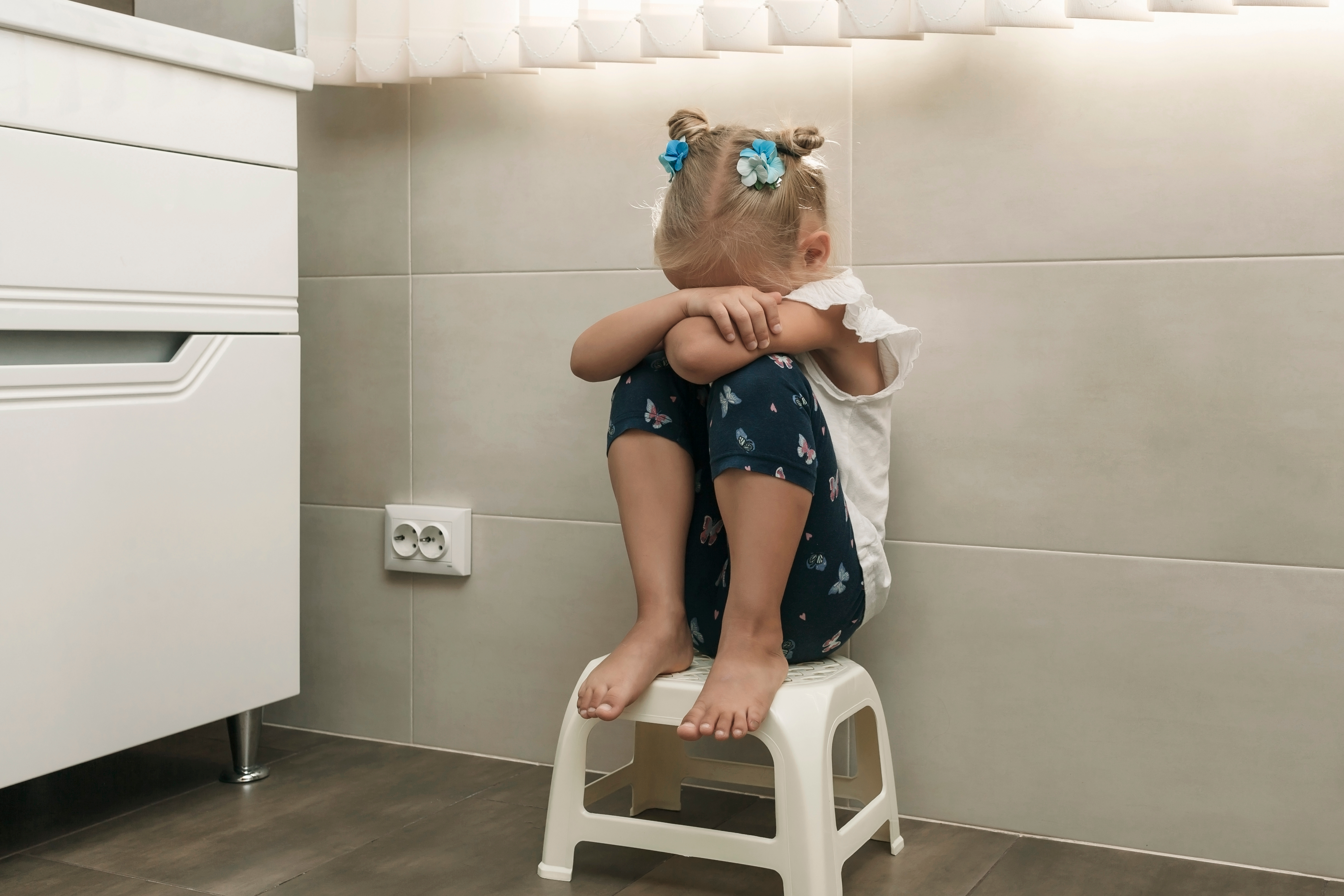 Little girl crying in the bathroom | Source: Shutterstock.com