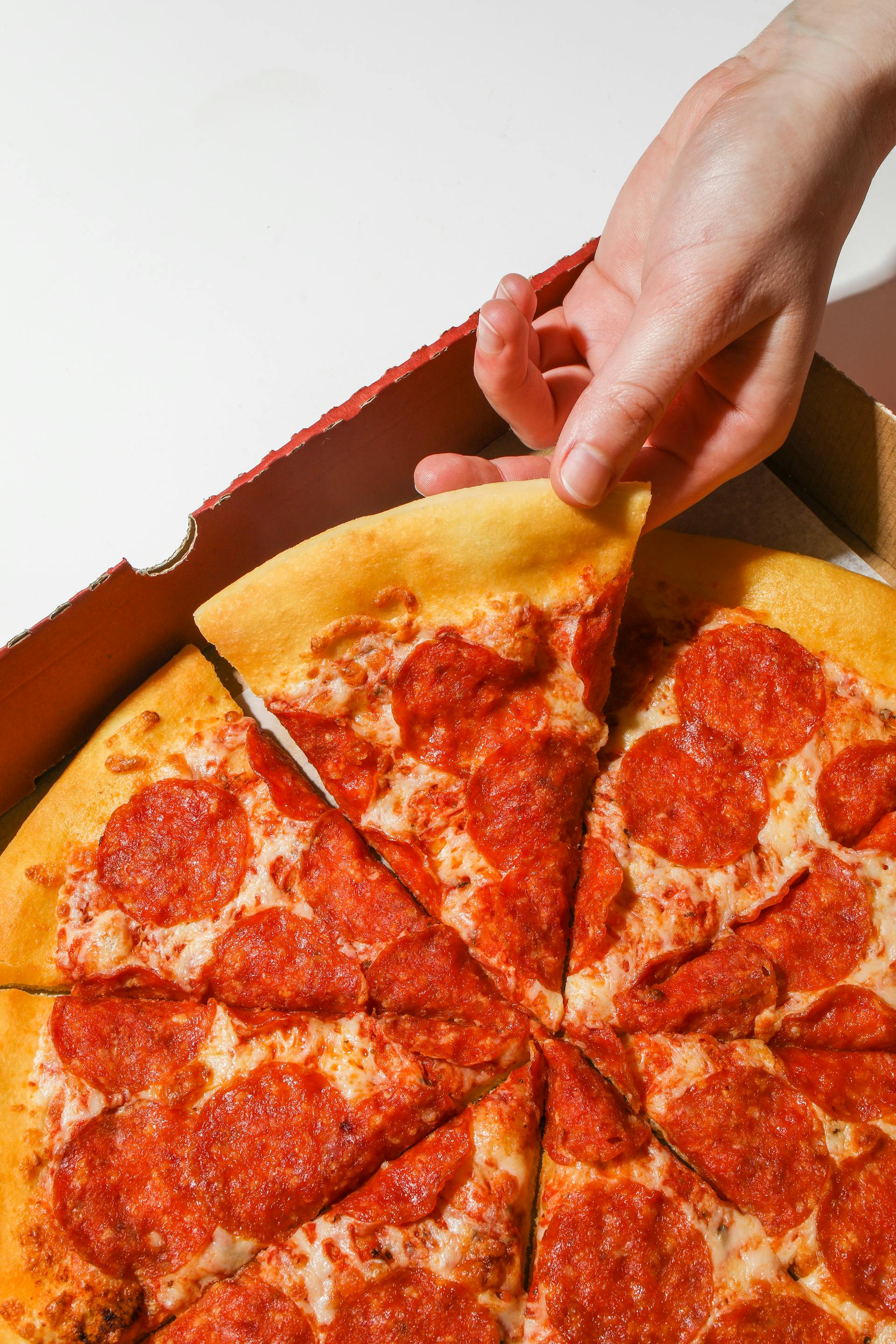 A person holding a slice of pizza | Source: Pexels