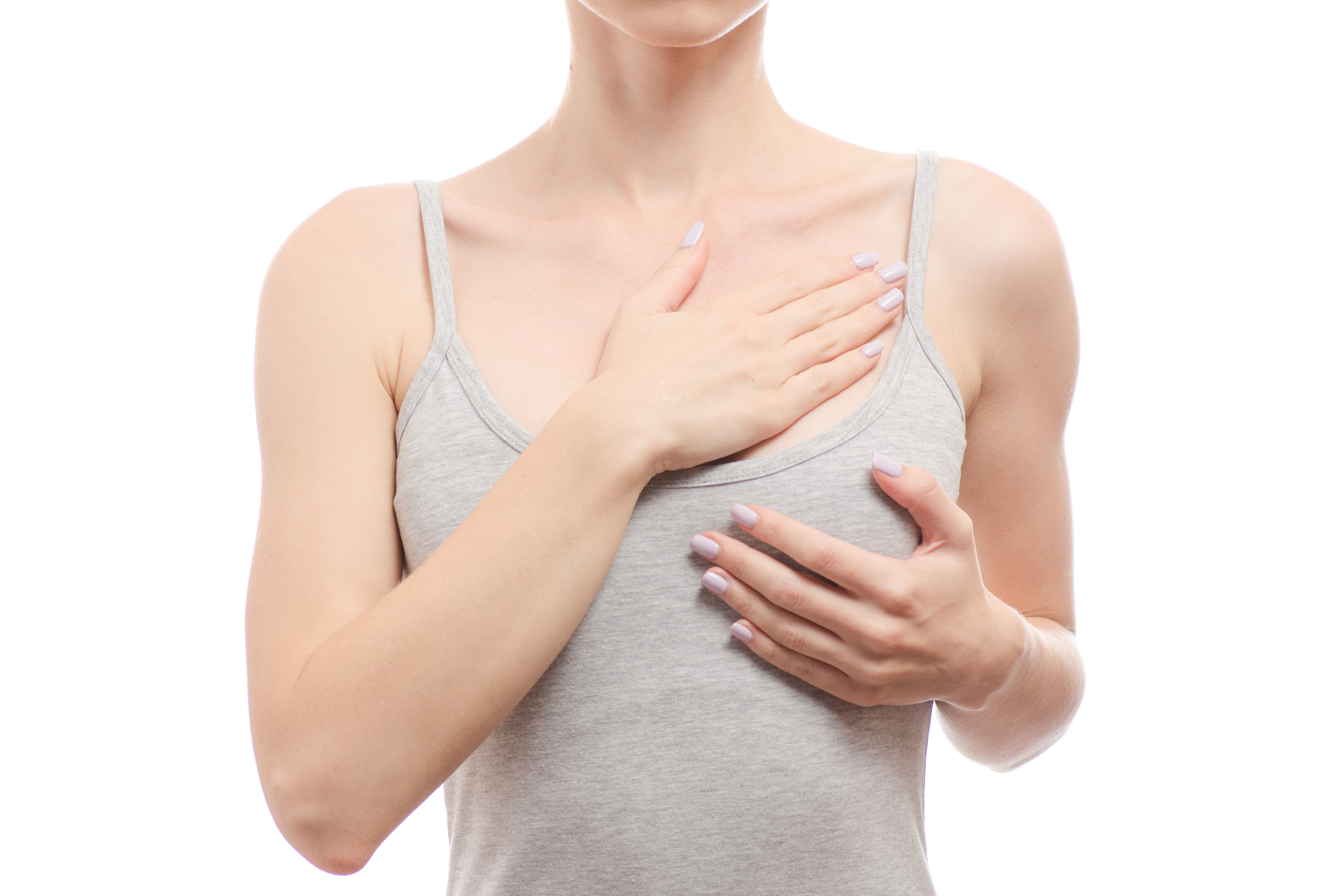 A woman placing her hands over her chest, representing a breast health awareness concept | Source: Getty Images