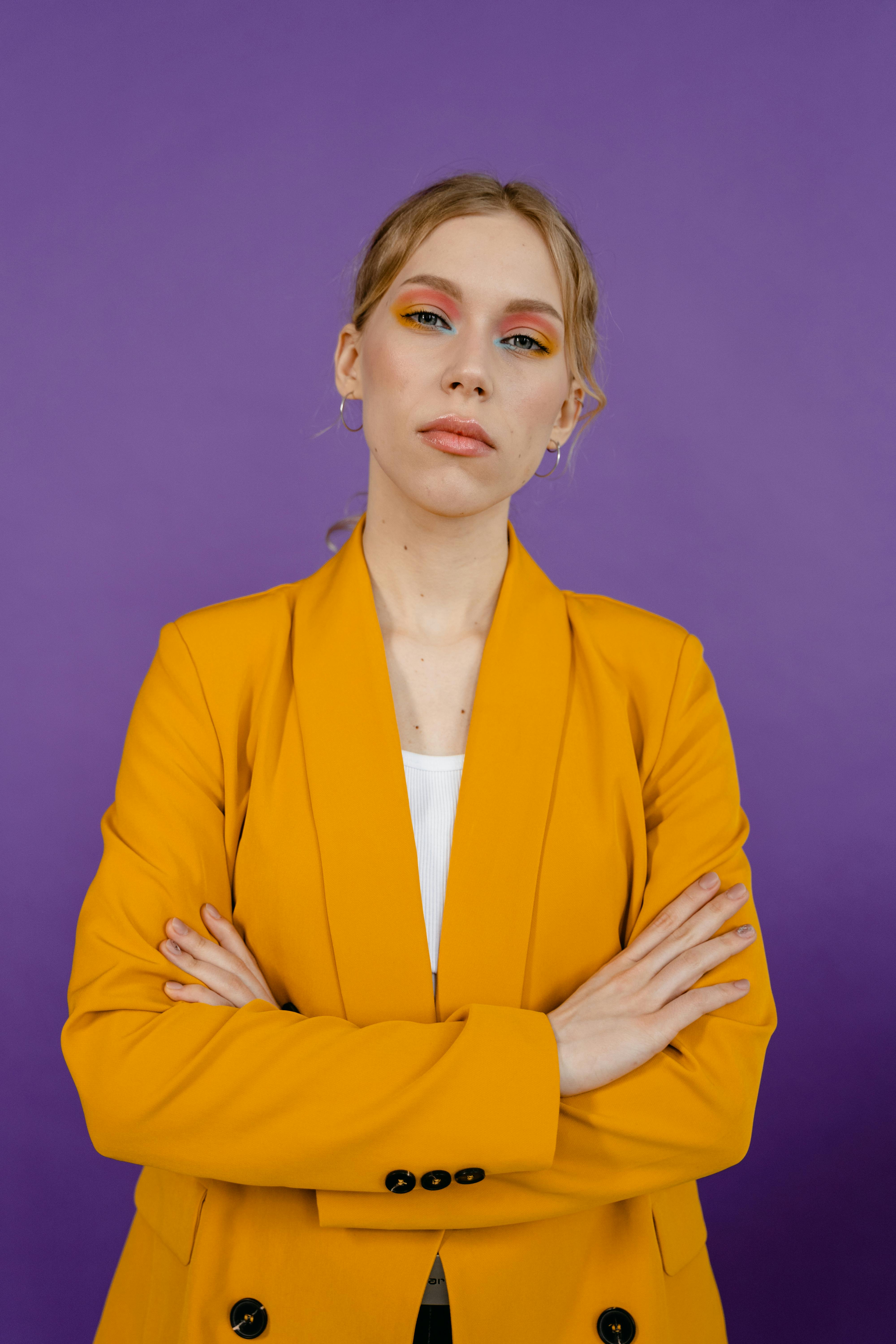 Frustrated woman in yellow suit crossing her arms | Source: Pexels