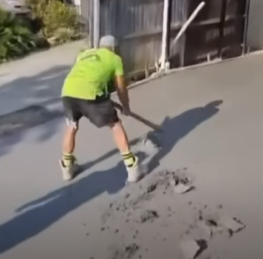 A concreter smashing a concrete driveway, from a video dated January 8, 2024 | Source: YouTube/7NEWS Australia