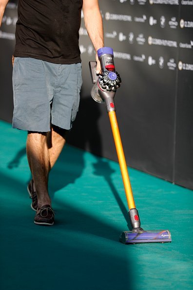 A worker using a vacuum cleaner | Photo: Getty Images