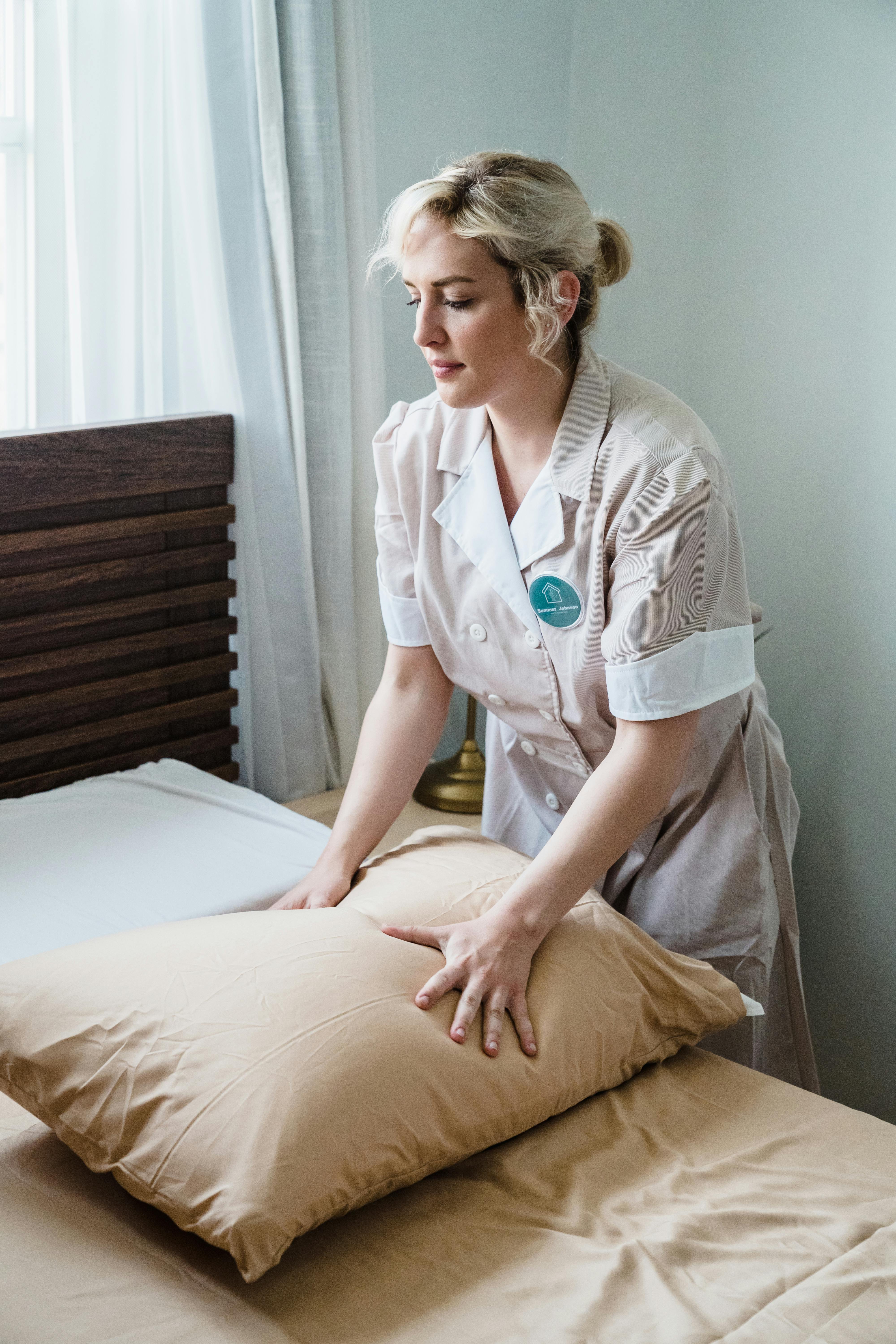 A hotel maid holding a pillow | Source: Pexels