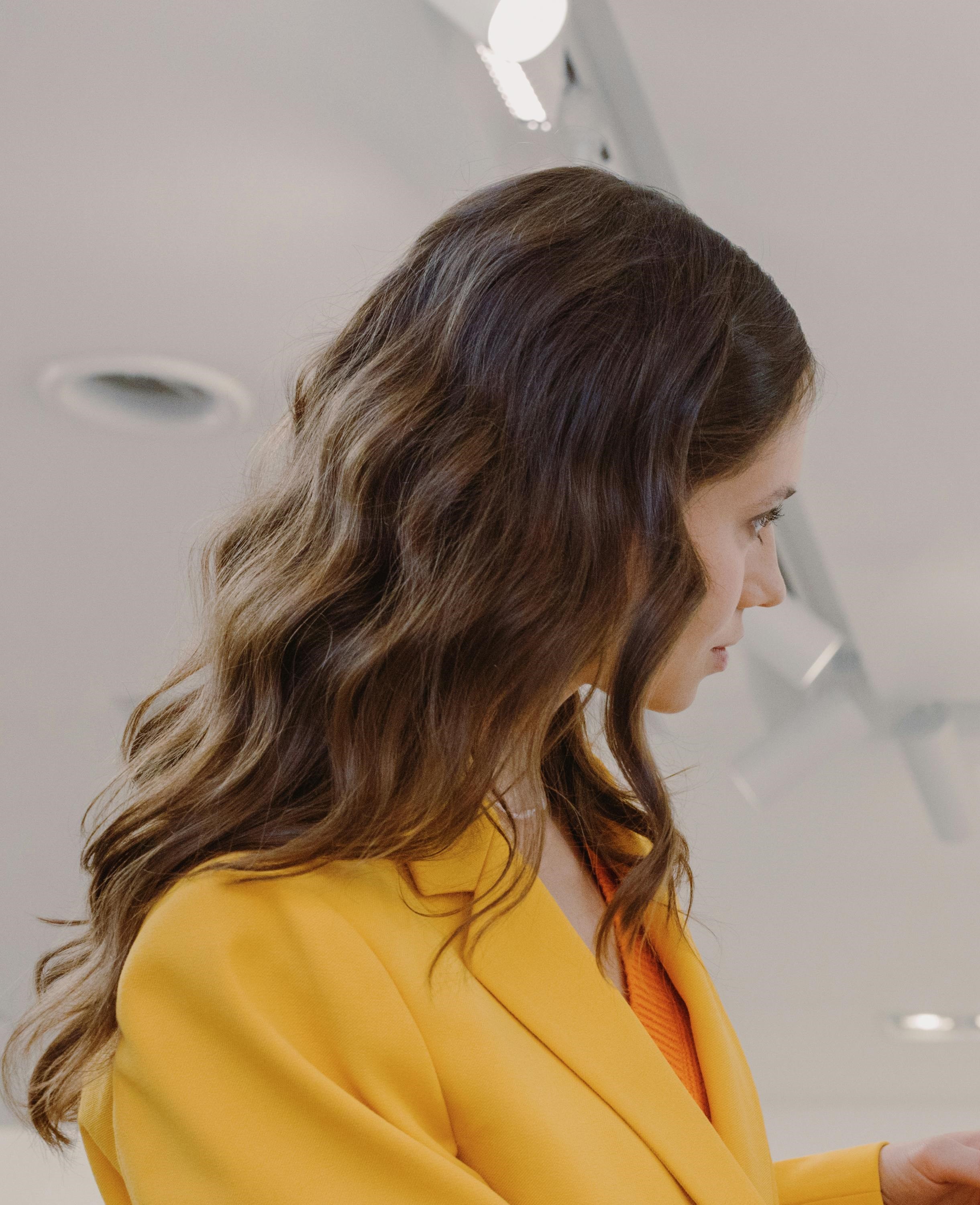 A woman in bright yellow suit talking to someone | Source: Pexels