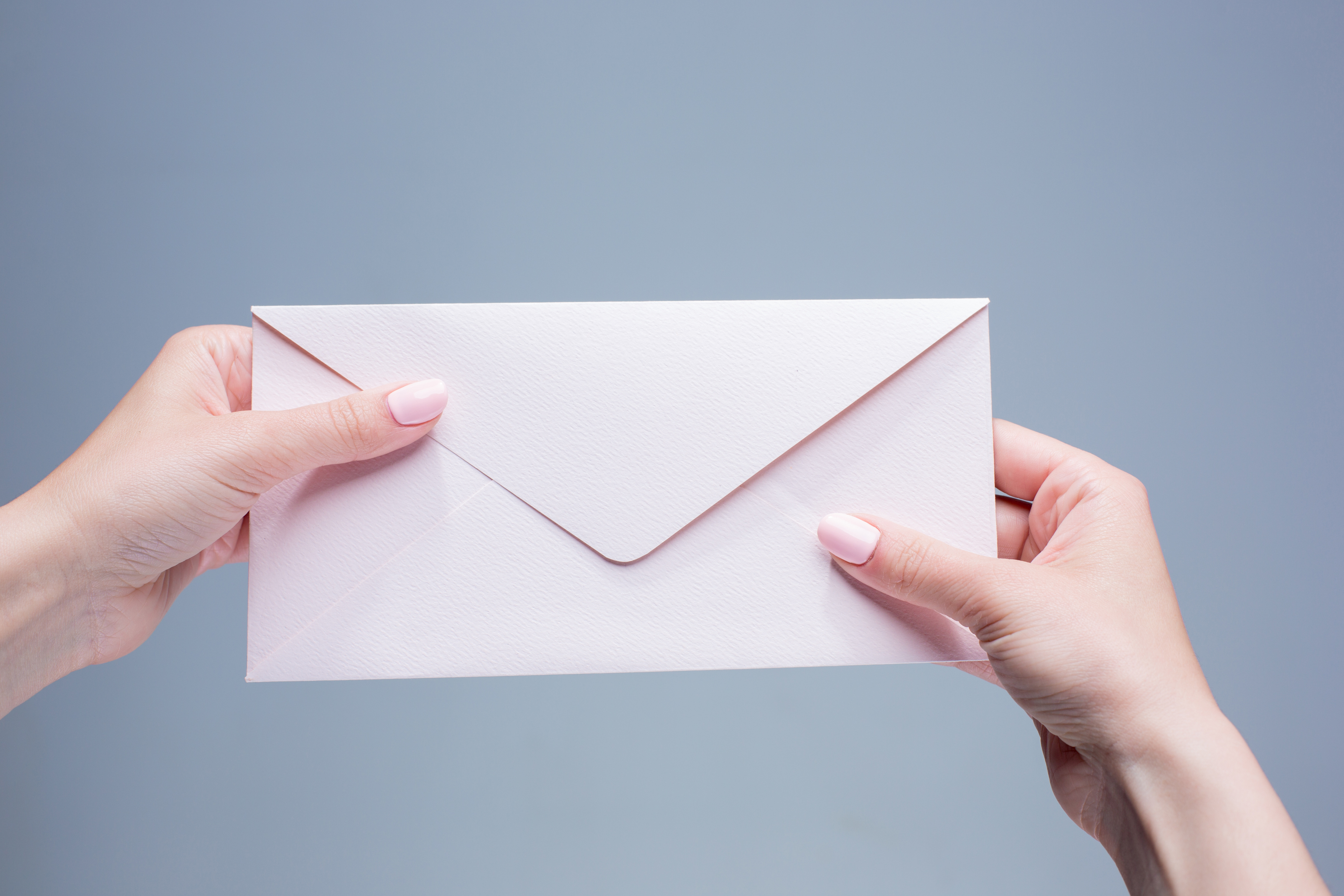 Close-up of a woman's hands holding an envelope | Source: Freepik