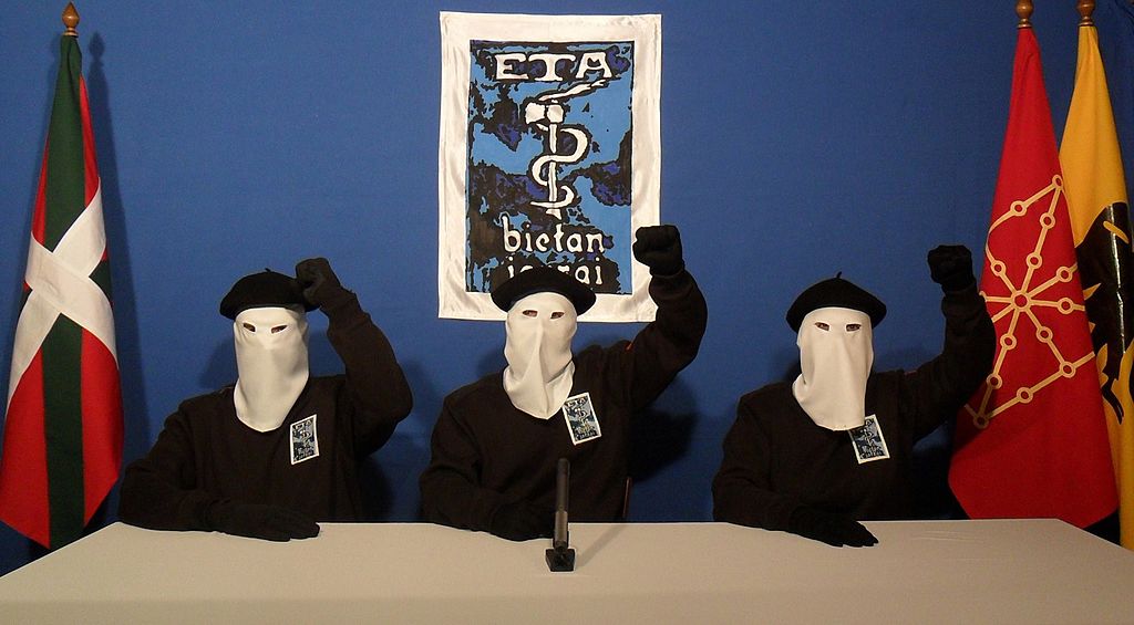 Tres militantes de ETA posan frente al símbolo del grupo en apoyo de una declaración publicada el 20 de octubre de 2011. | Foto: Getty Images