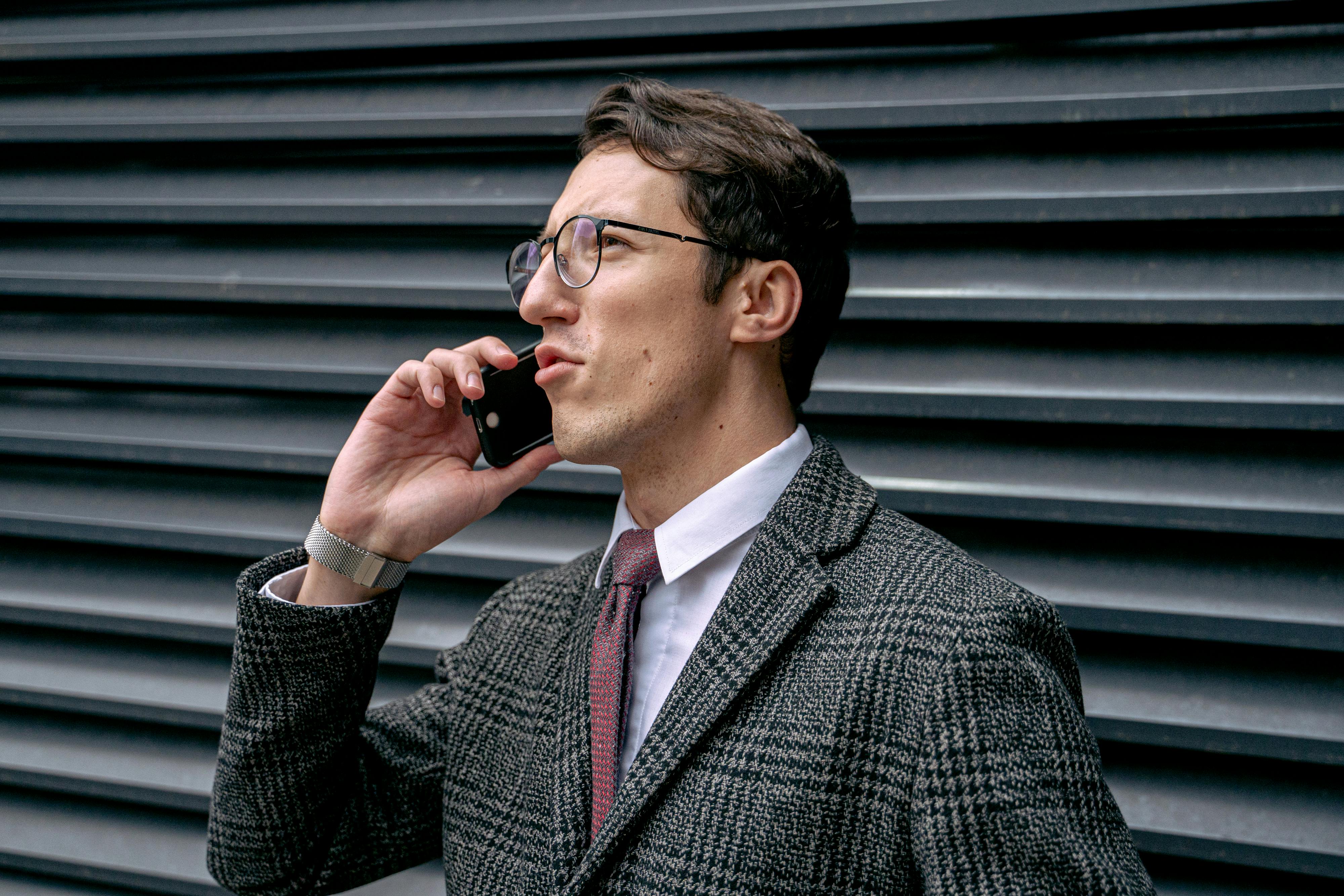 A man in a suit talking on a phone | Source: Pexels