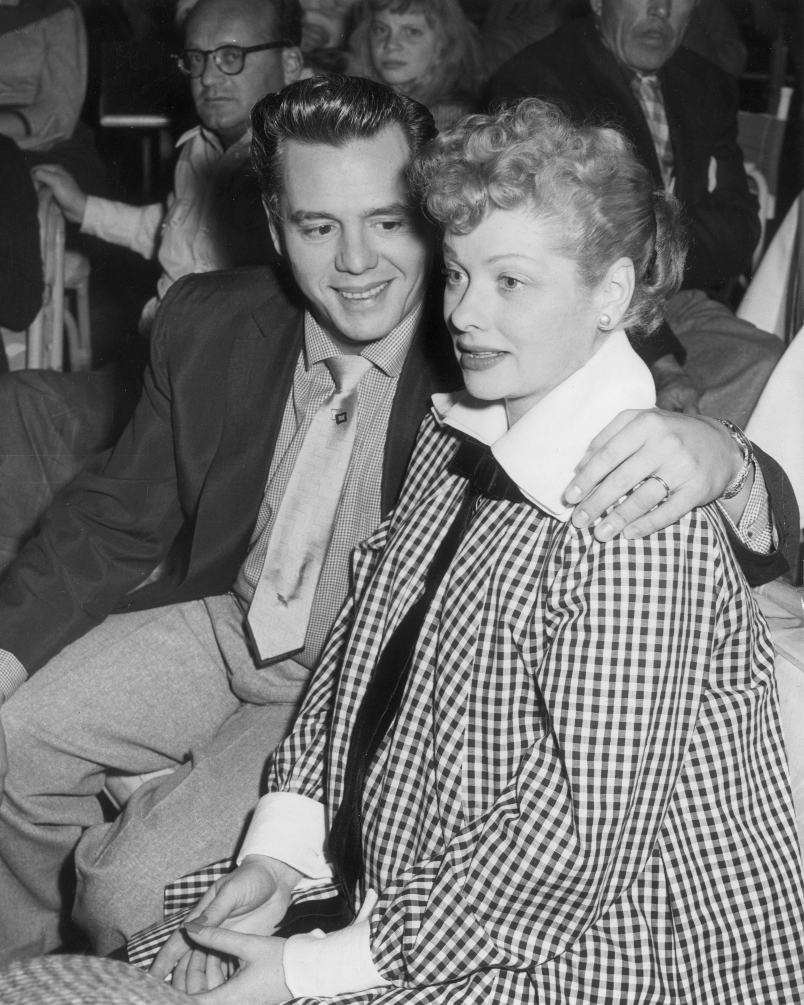 Desi Arnaz embraces his wife, Lucille Ball while watching a televised football game at the Racquet Club in Palm Springs, California, circa 1953 | Photo: Getty Images
