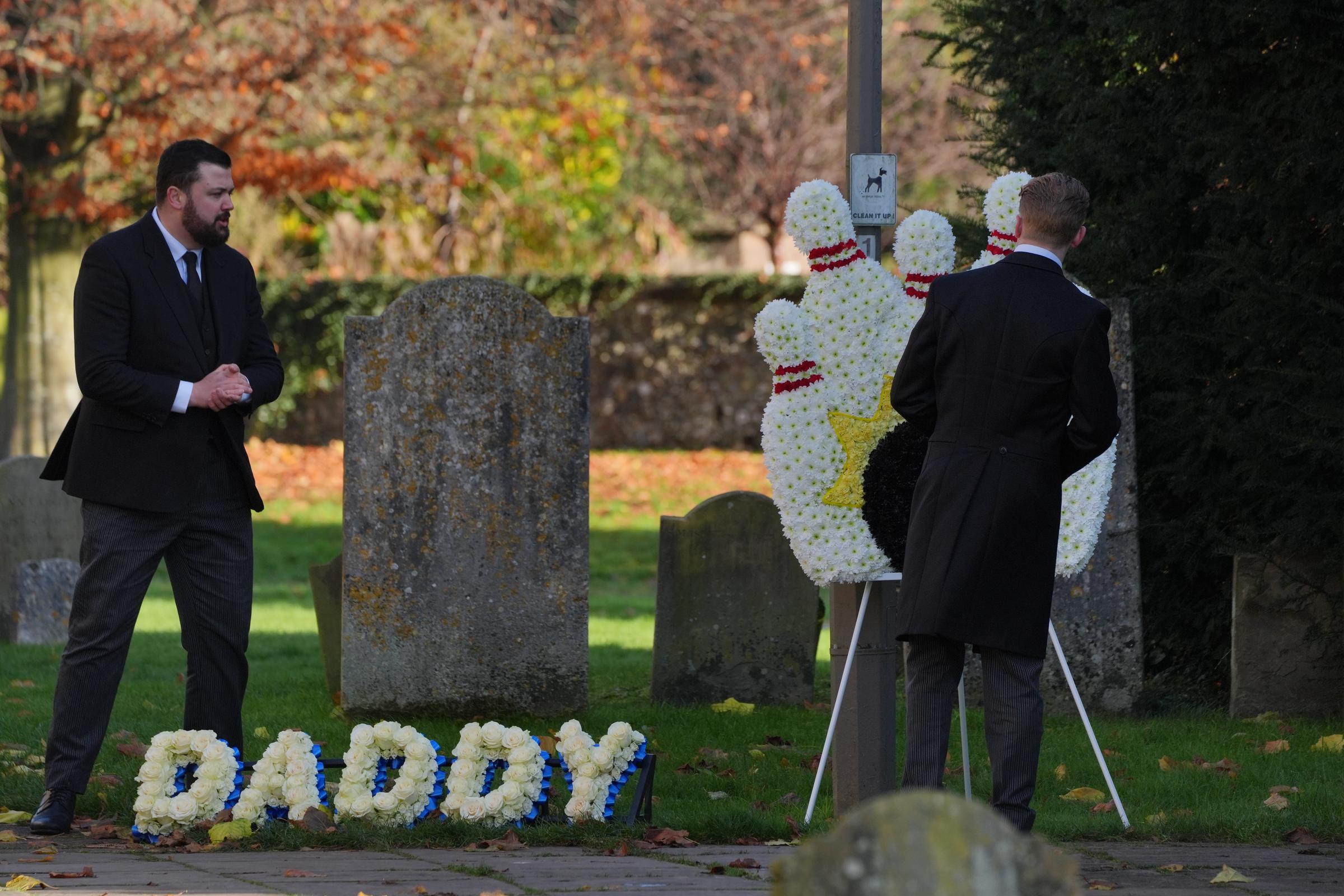 A funeral director places a floral tribute which says "Daddy" in the churchyard at Liam Payne's funeral service on November 20, 2024, in Amersham, England. | Source: Getty Images