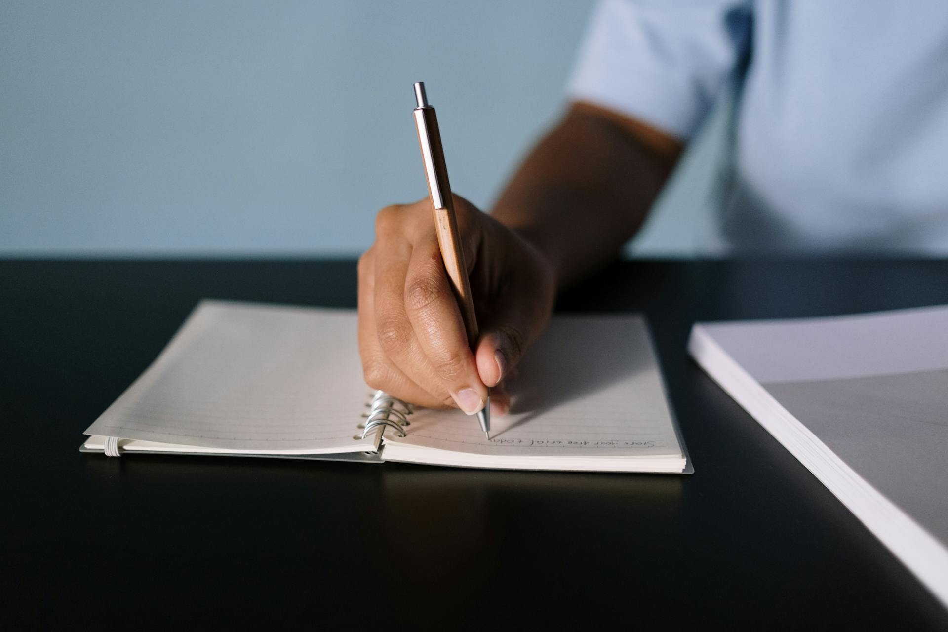 A boy writing on a piece of paper | Source: Pexels